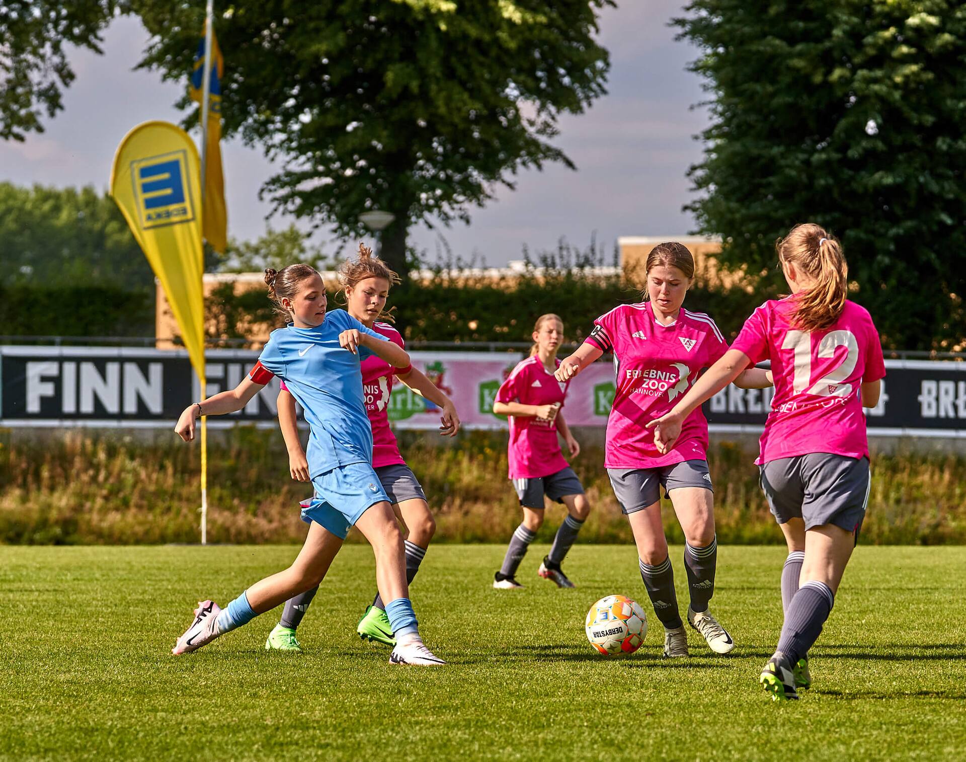 Zwei Teamkapitäninnen weiblicher Fußball-Jugendteams im Zweikampf um den Ball.
