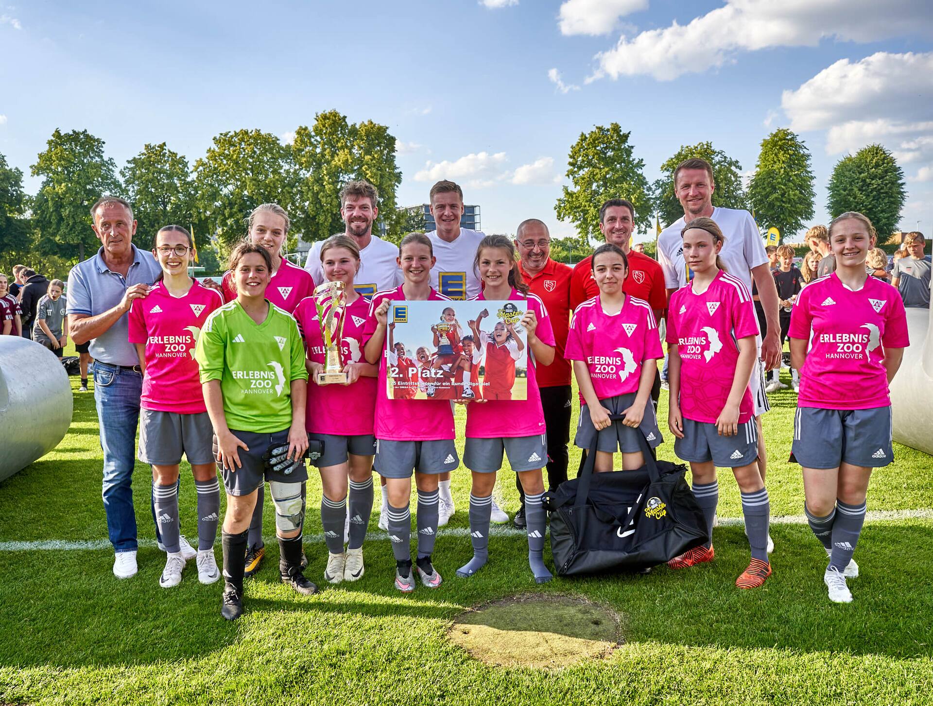 Weibliches Jugend-Fußballteam posiert mit einer Urkunde für den 2. Platz.