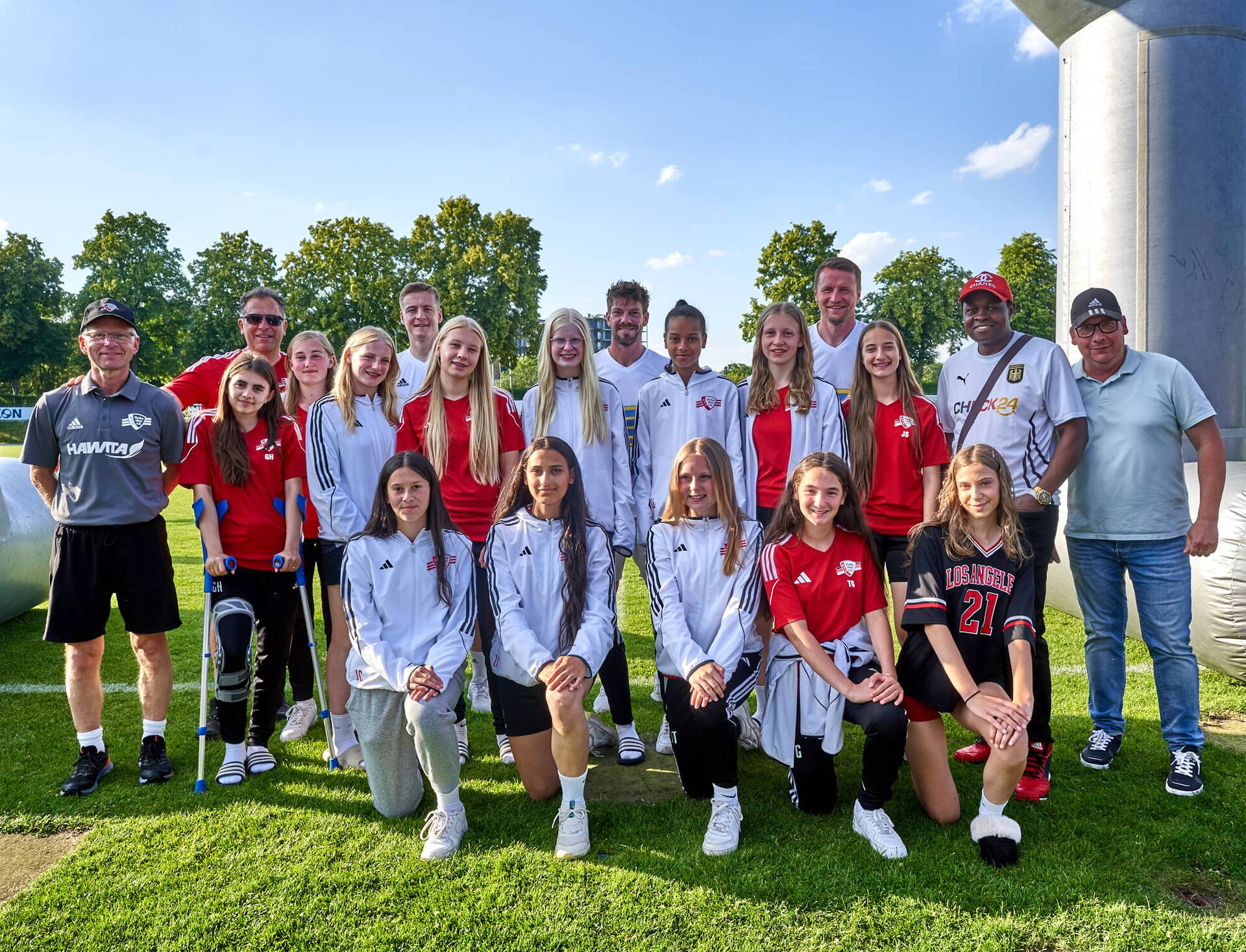 Weibliches Jugend-Fußballteam posiert abseits des Spielfeldes.