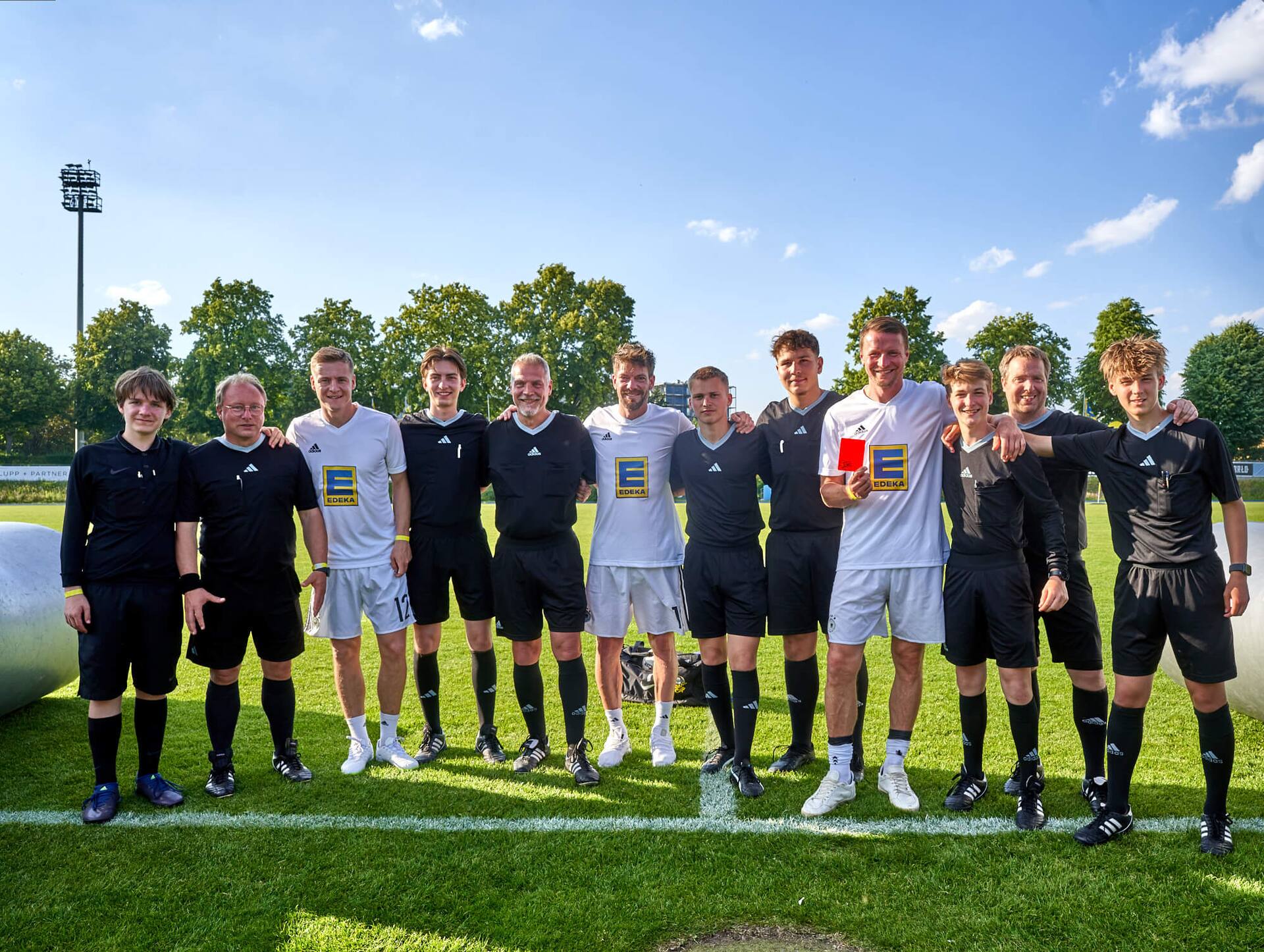 Ex-Profis und Schiedsrichter stehen zusammen.