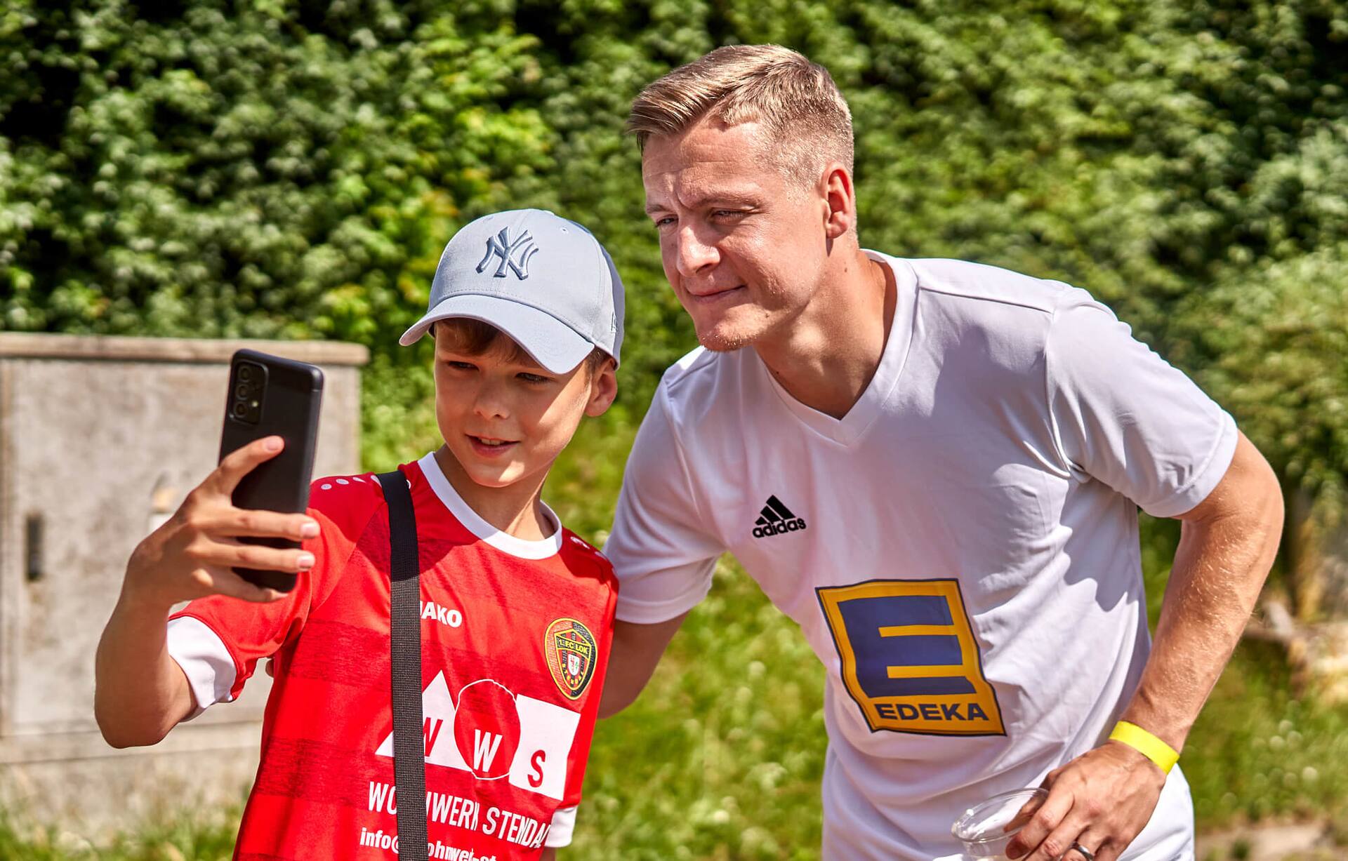 Ein Junge macht ein Selfie mit Ex-Profi Felix Kroos.