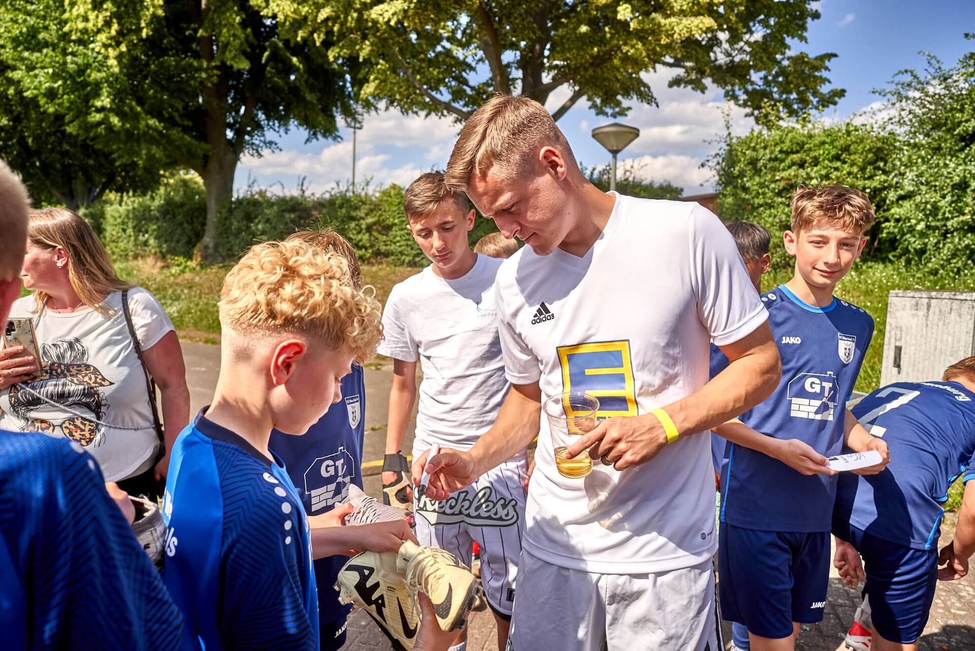 Ex-Profi Felix Kroos gibt Kindern Autogramme.