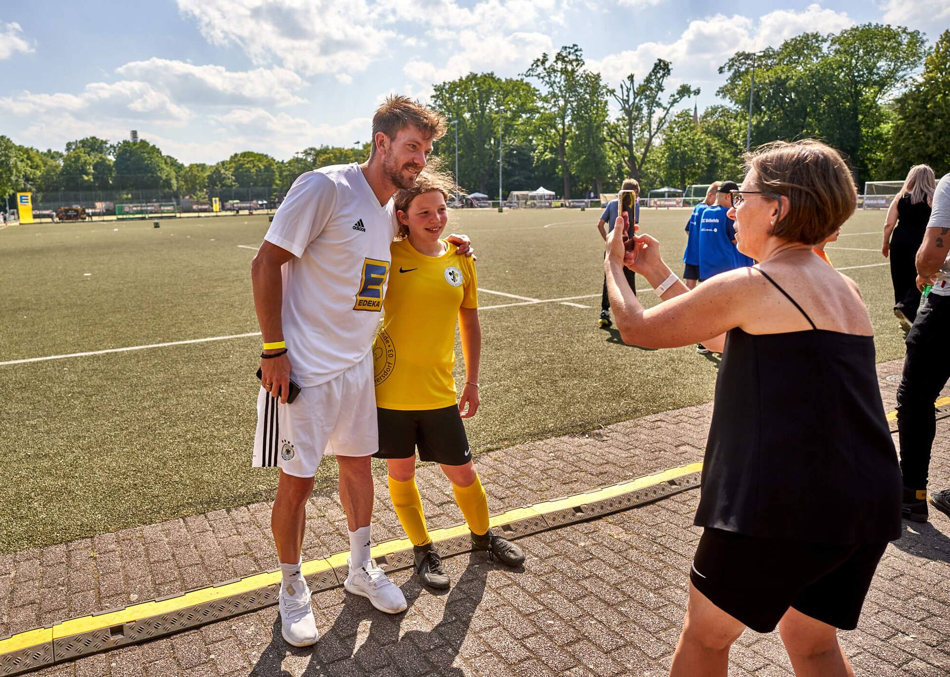 Ex-Profi Thorben Marx posiert für ein Foto mit einer Jugendspielerin.