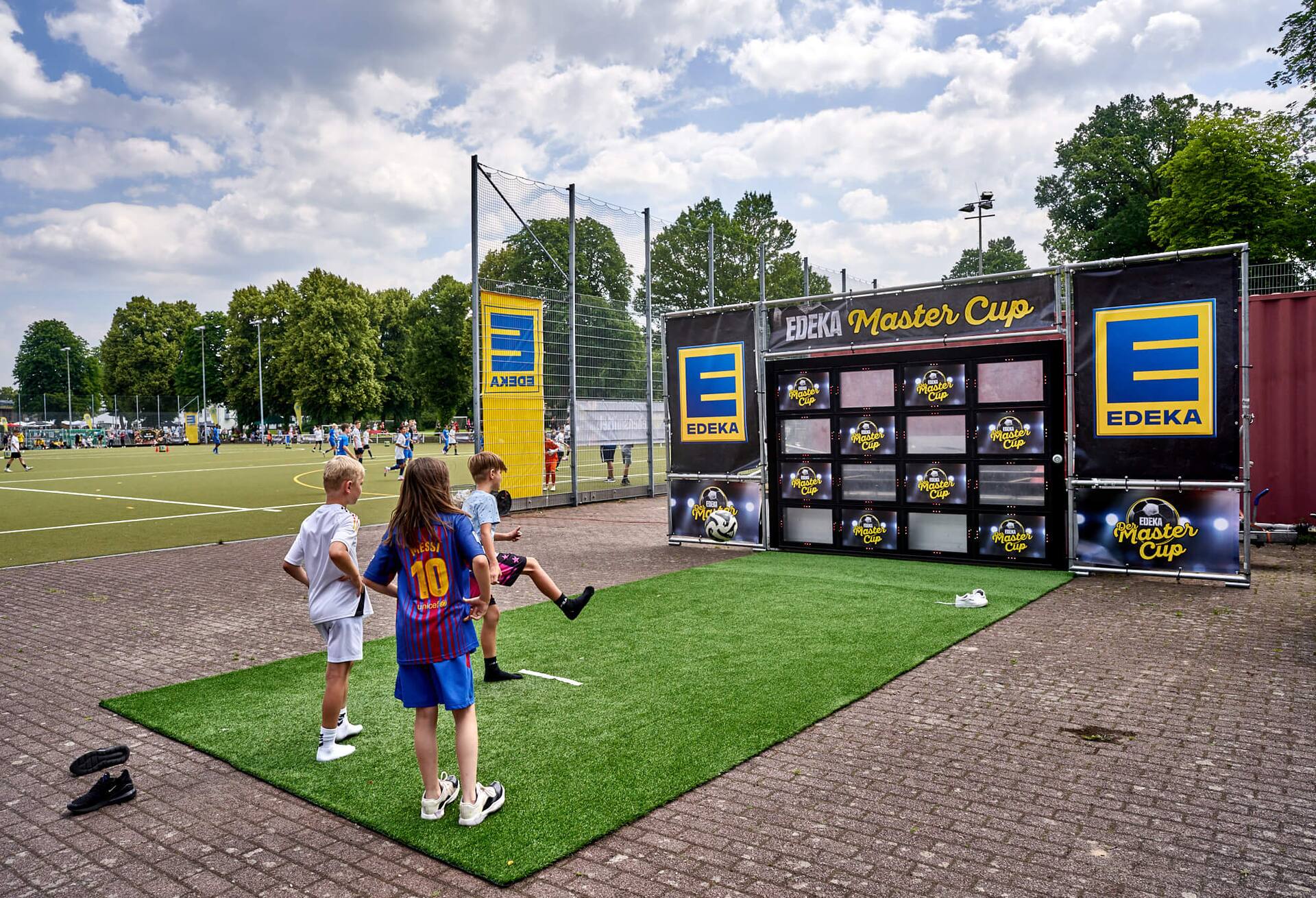 Ein Junge schießt auf eine Torwand, an der EDEKA Master Cup steht.