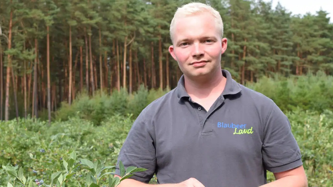 Portrait des Geschäftsführers Hannes Badenhop vor einem Feld.