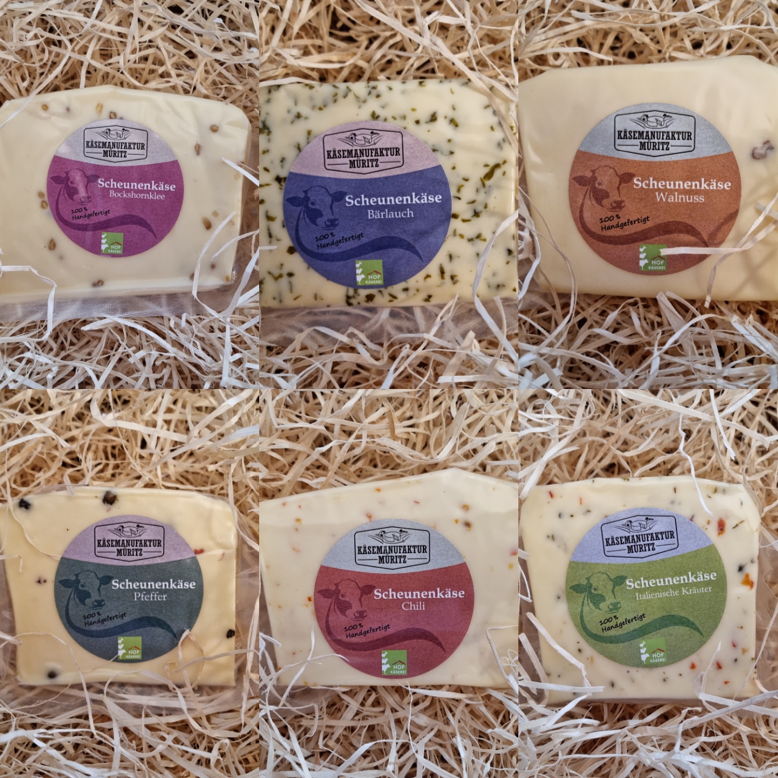 Sechs Packungen Scheunenkäse liegen auf Holzspäne: Bockshornklee, Bärlauch, Walnuss, Pfeffer, Chili sowie Italienische Kräuter.