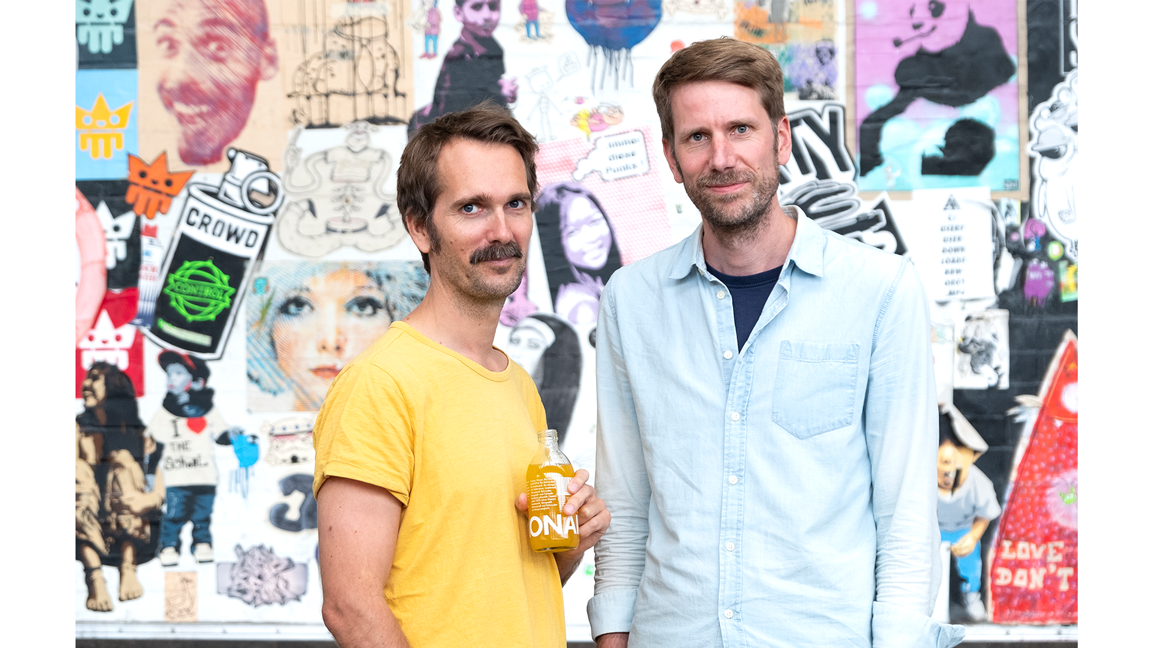 Die Gründer mit einer Flasche in der Hand.