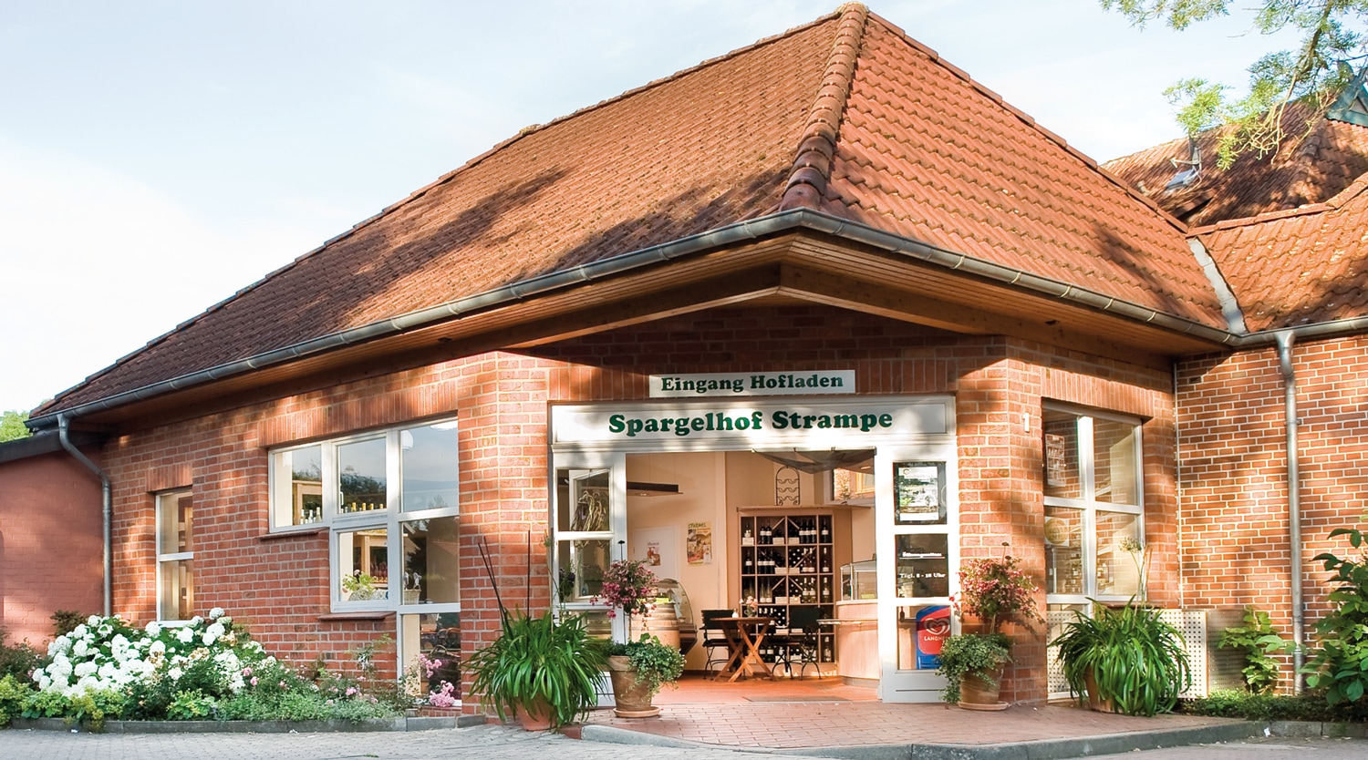 Eingang des Hofladens vom Spargelhof Strampe. Rote Mauersteine und rote Dachziegel.