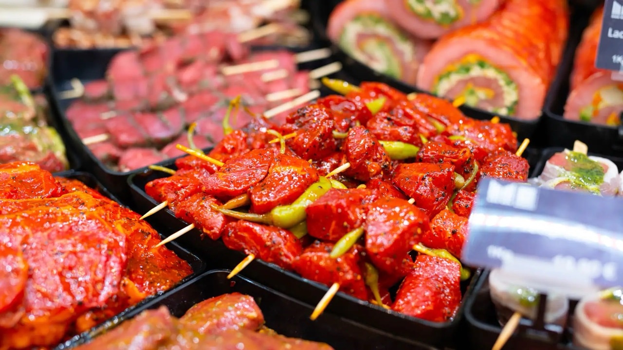 Rot marinierte Fleischspieße mit grünen Pepperonis.