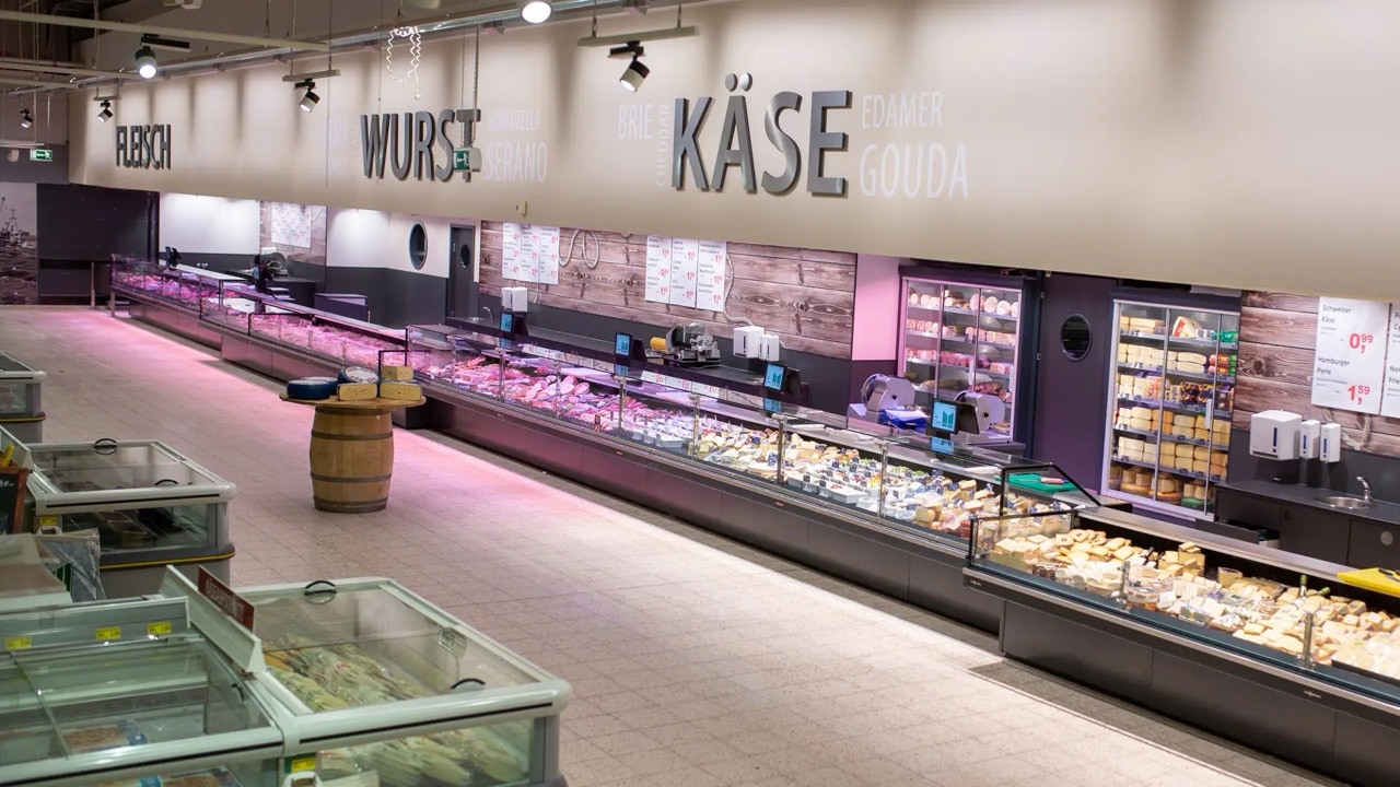 Luftaufnahme der langen Frischetheke für Fleisch, Wurst und Käse.