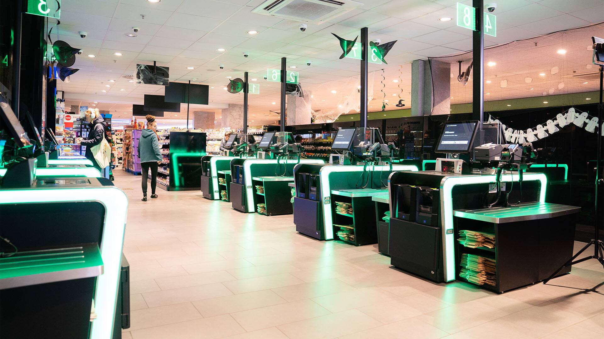 Hellgrün beleuchtete Selbstbedienungskassen.