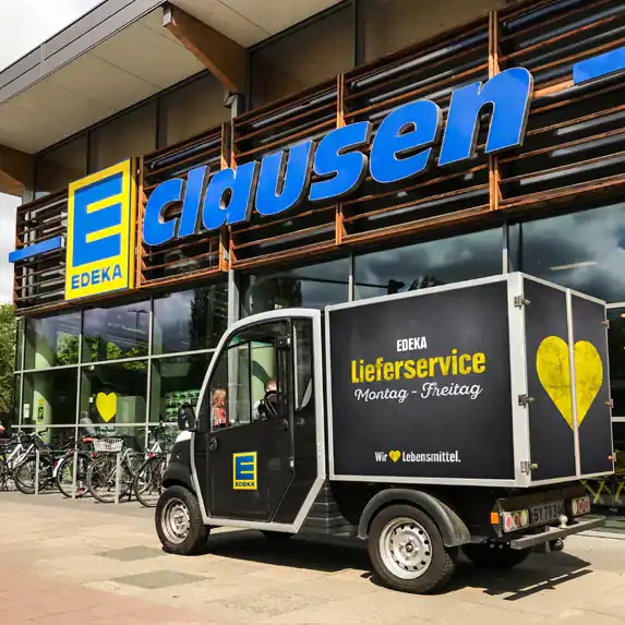 Kleiner schwarzer Lieferwagen vor der Filiale EDEKA Clausen.