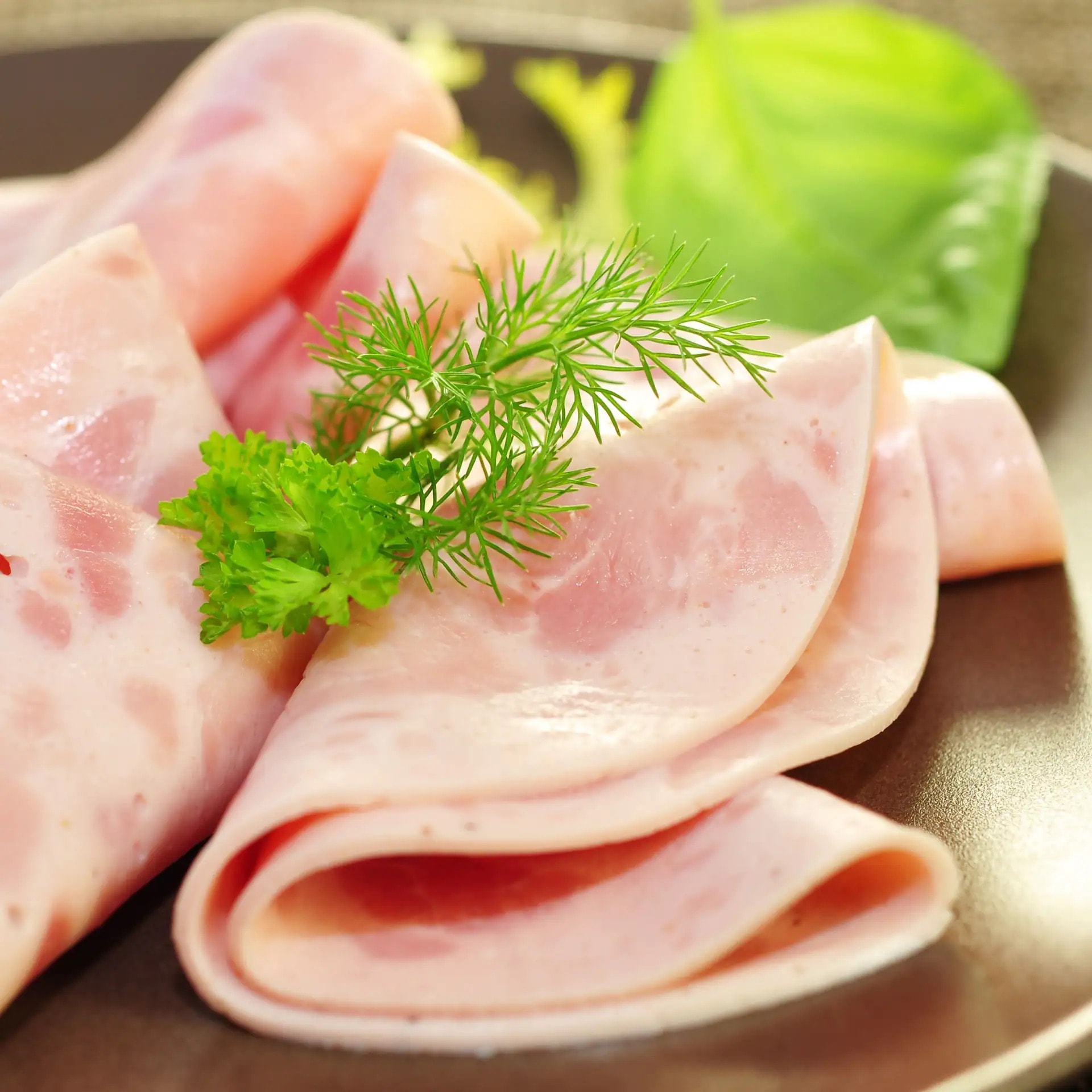 Vier gefaltete Scheiben Schinkenwurst.