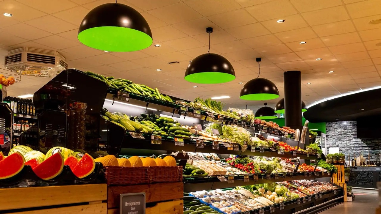 Die Obst- und Gemüseabteilung wird von schwarz-grünen Lampen ausgeleuchtet.