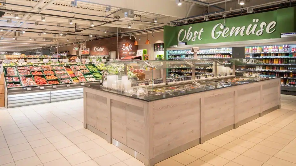 Obst- und Gemüseabteilung im Markt. Davor eine freistehende Selbstbedienungs Salatbar.