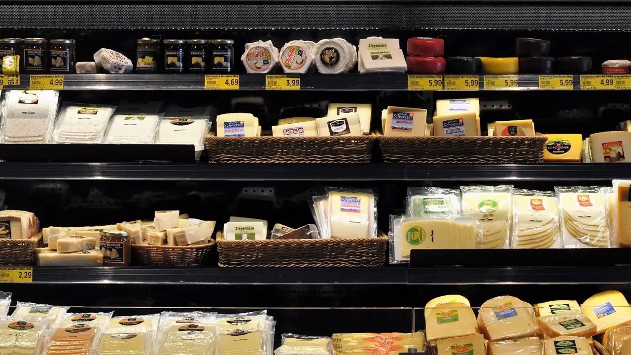 Nahaufnahme der Auslage mit verpacktem Käse in vier Regalen.