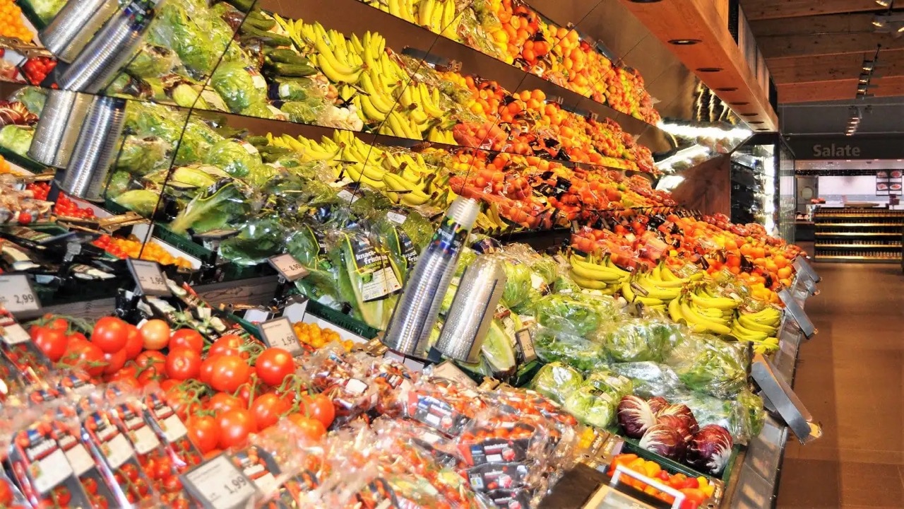 Obst- und Gemüseauslage mit Tomaten, Salat, Bananen und Äpfeln.