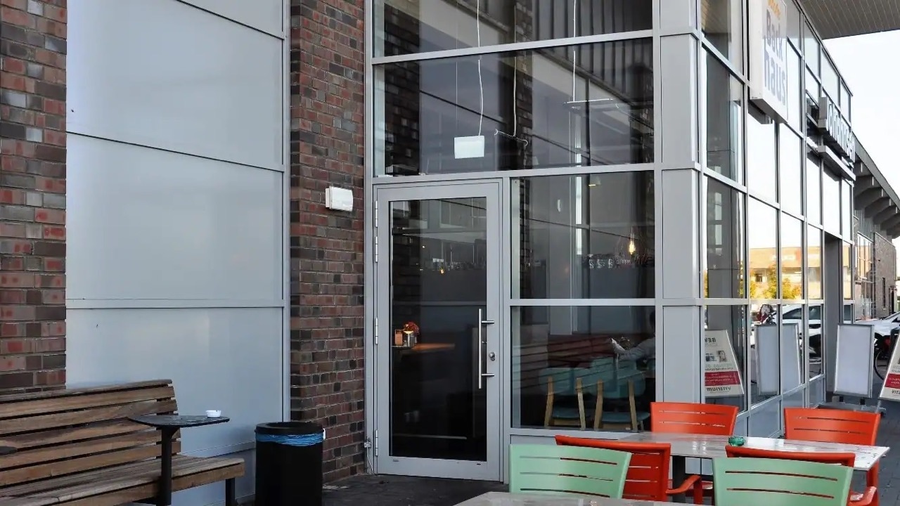 Stühle und Tische sowie eine Bank mit Tisch vor dem Seiteneingang.