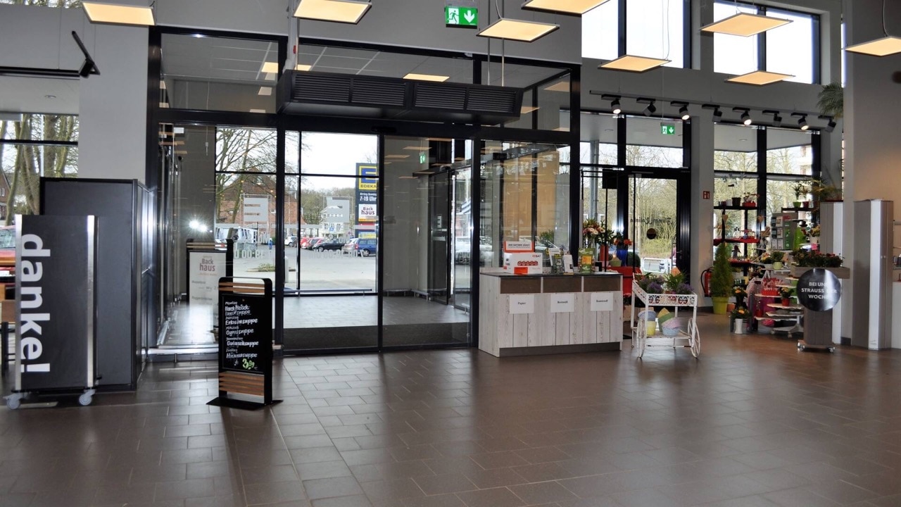 Ein- und Ausgangsbereich von innen. Durch die Schiebetür sieht man den Parkplatz.