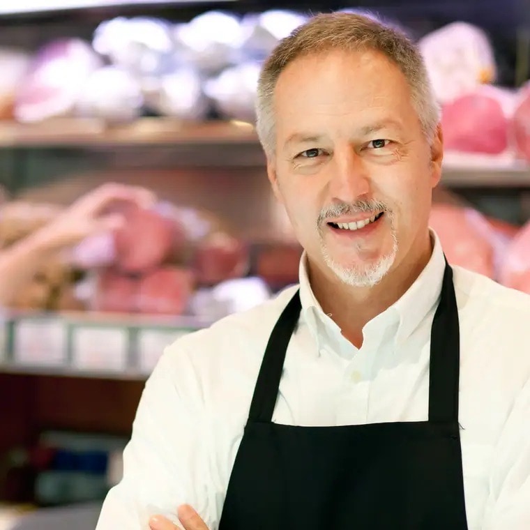 Mann mit weißem Hemd und schwarzer Schürze.