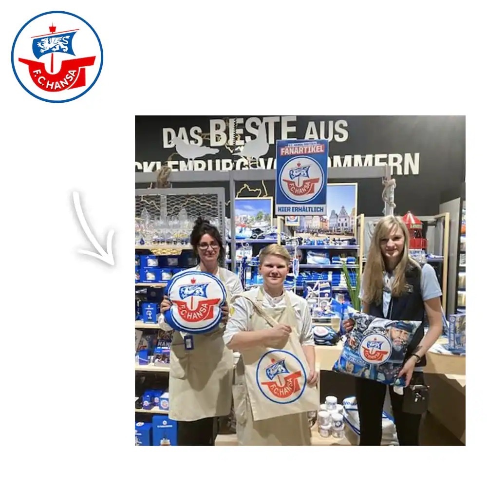 Drei Personen halten Kissen und Jutebeutel von Hansa Rostock hoch.