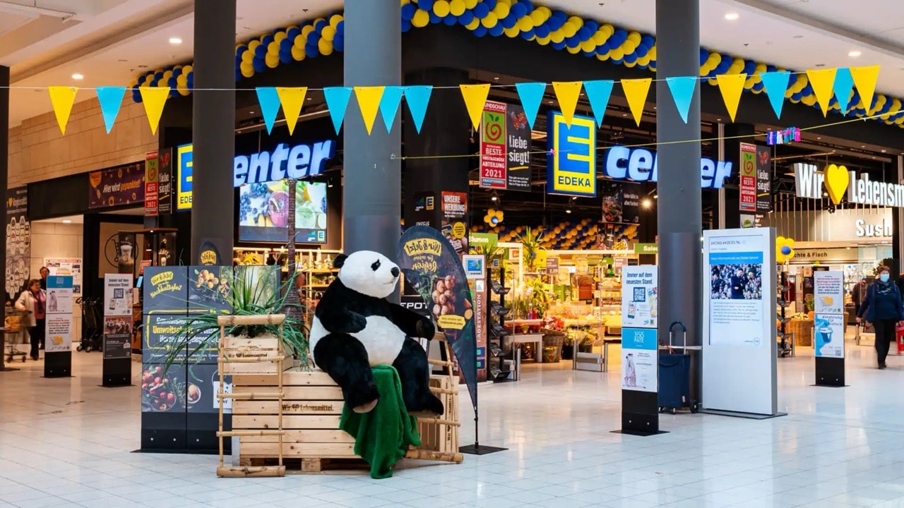 Auf Paletten am Eingang sitzt ein Pandabär.