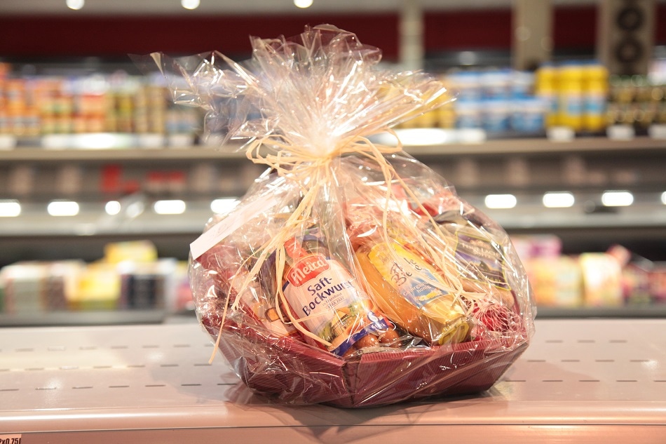 Kleiner Präsentkorb in Klarsichtfolie mit heller Schleife.