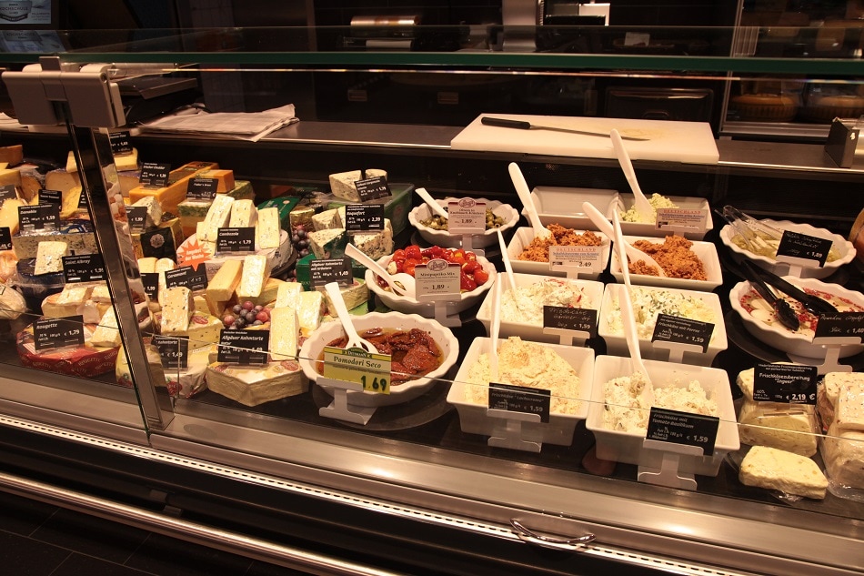 Auslage für Käse und Antipasti in der Frischetheke.