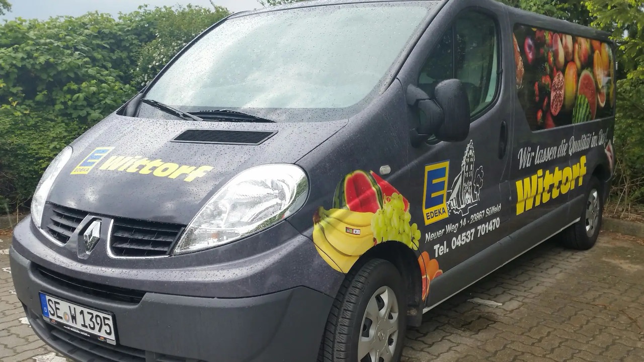 Schwarzer Van mit Beklebung von EDEKA Wittorf. Wir lassen die Qualität im Dorf.
