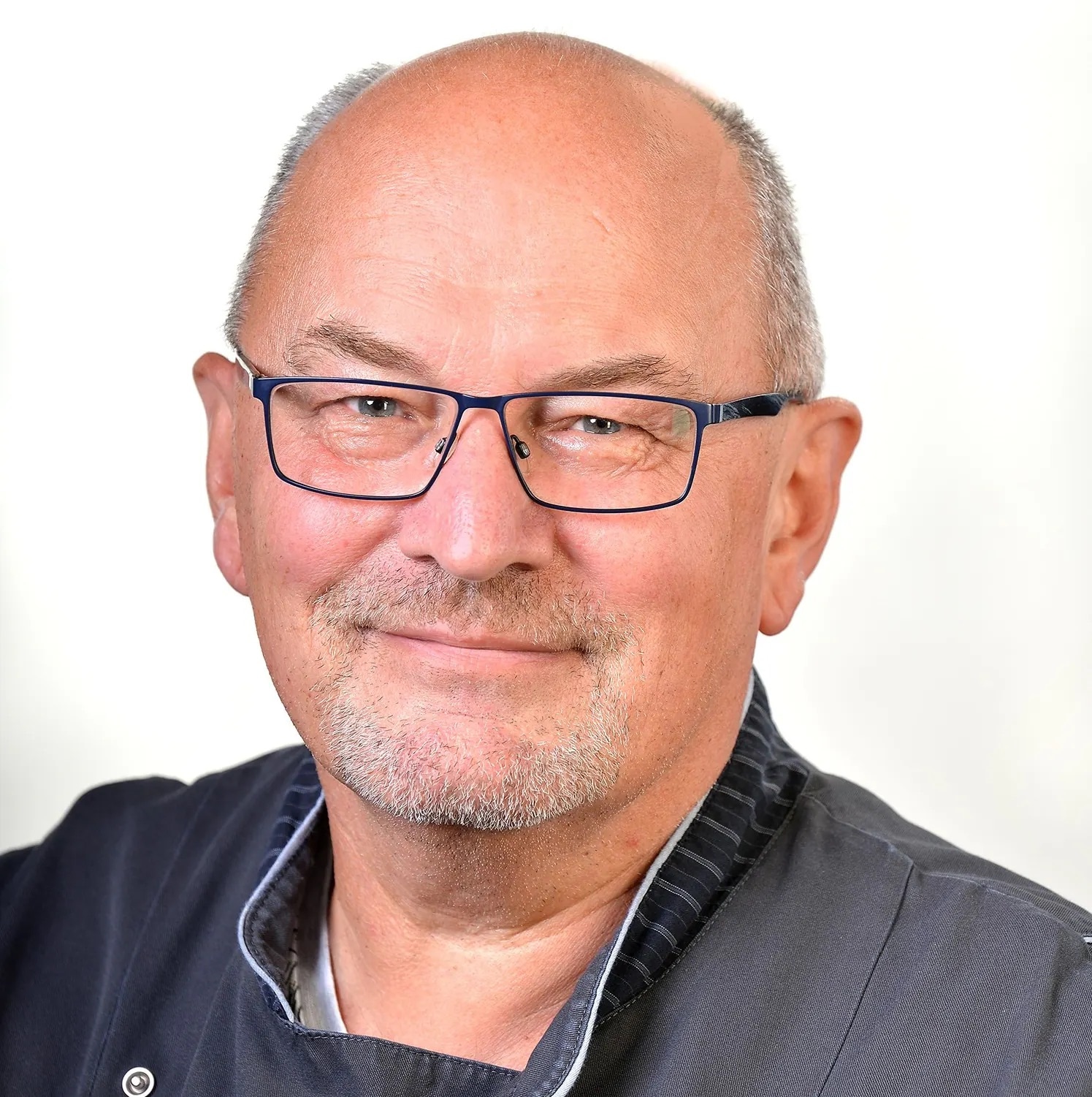 Das Portrait eines lächelnden Mitarbeiters.