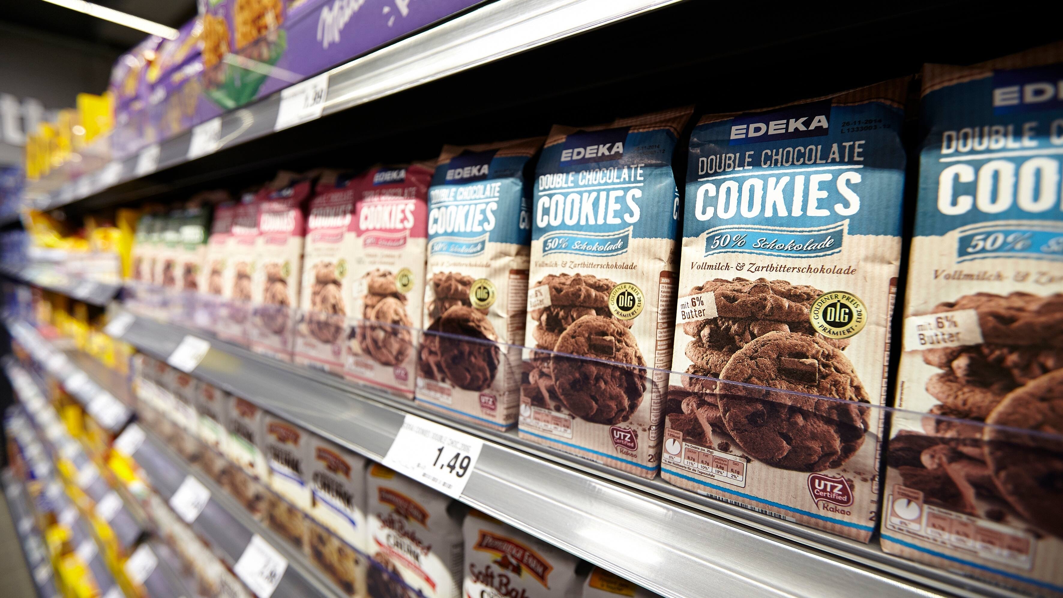 Eine Regal mit verschiedenen Arten von Gebäck. Im Fokus Cookies von EDEKA.