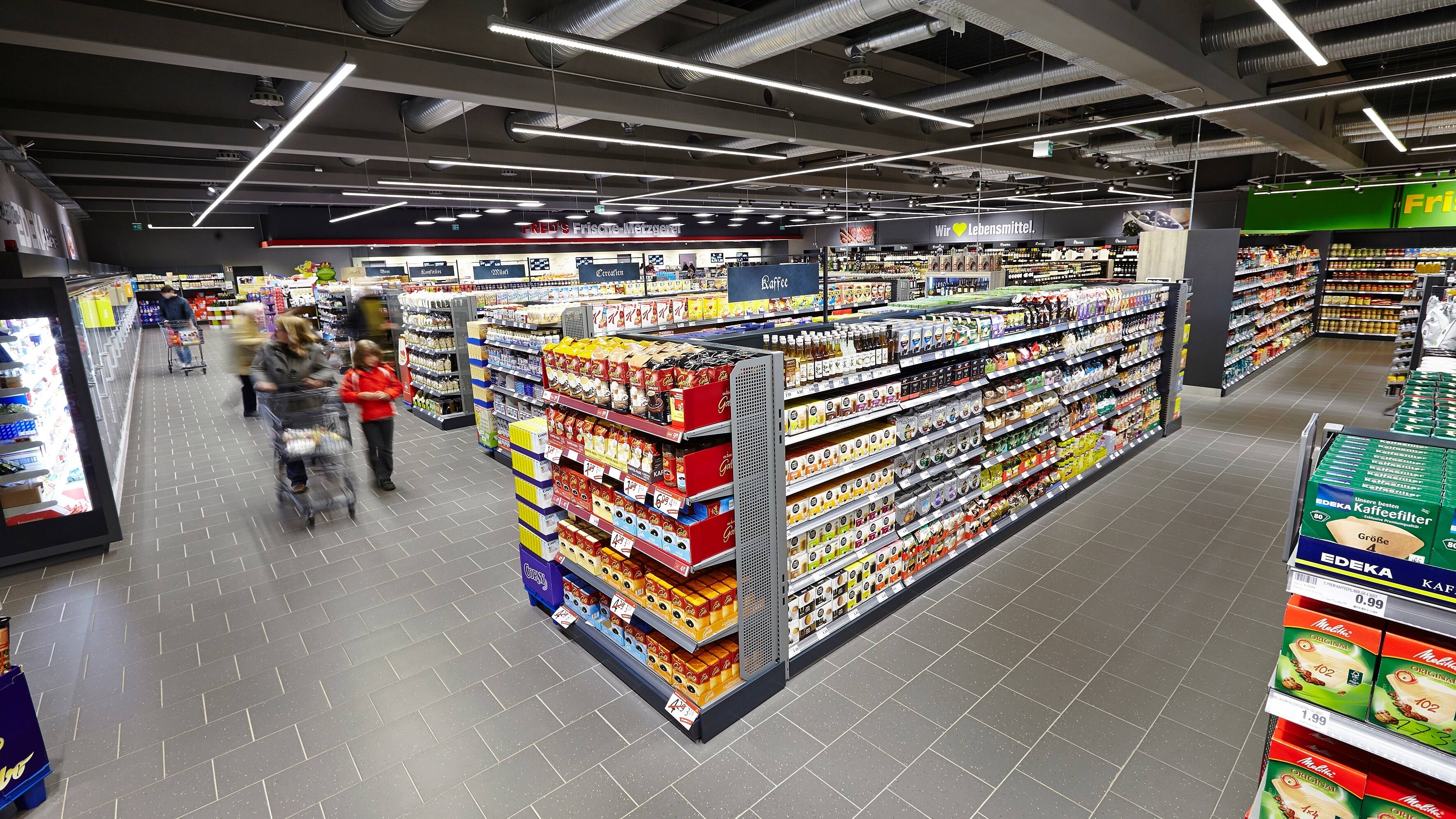 Ein Blick über die verschiedenen Regalreihen eines EDEKA-Marktes.