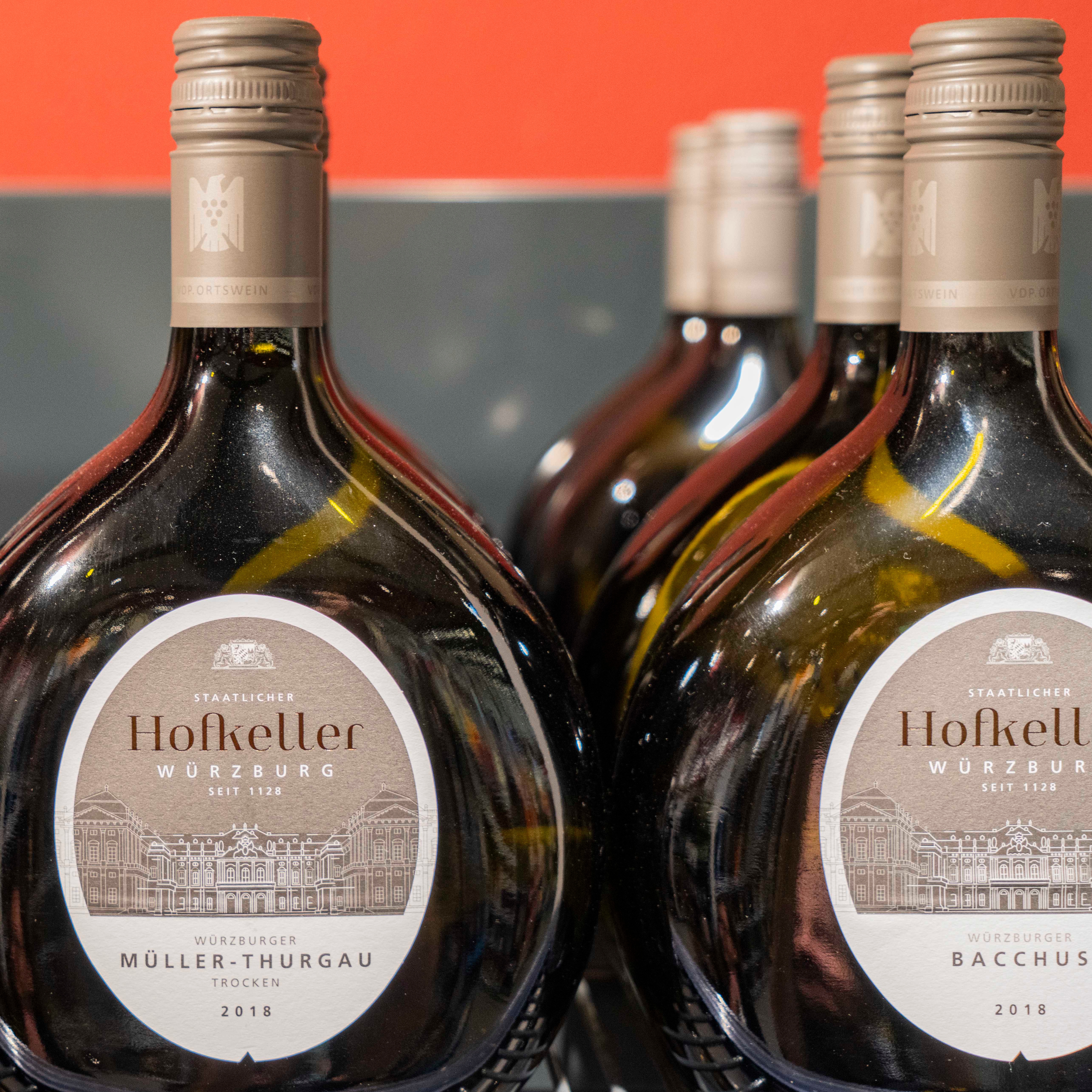 Nahaufnahme von identischen Weinflaschen, die hintereinander aufgereiht stehen.