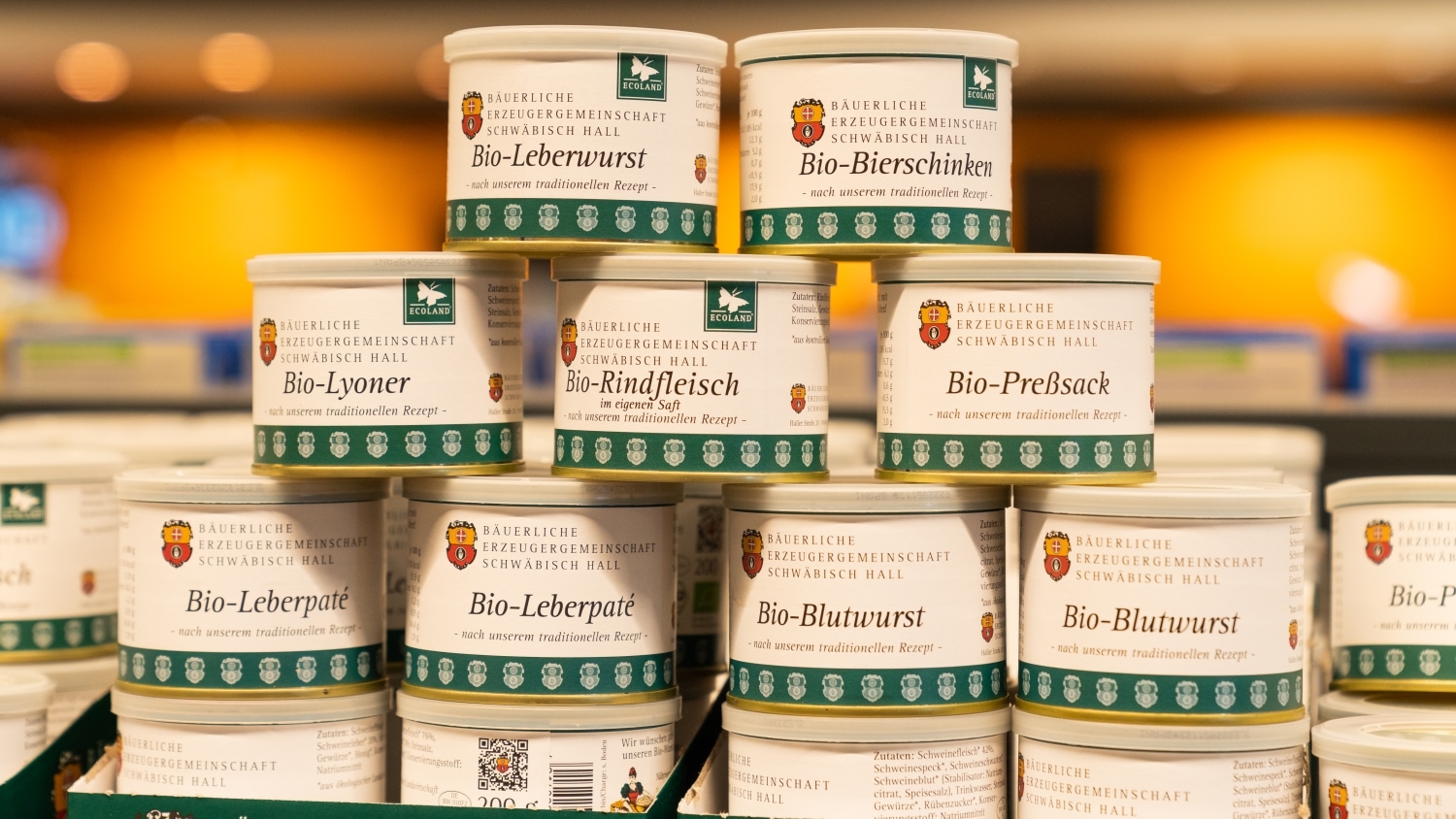 Ein Stapel mit Dosen in denen verschiedene Bio-Wurst- und Fleischspezialitäten enthalten sind.