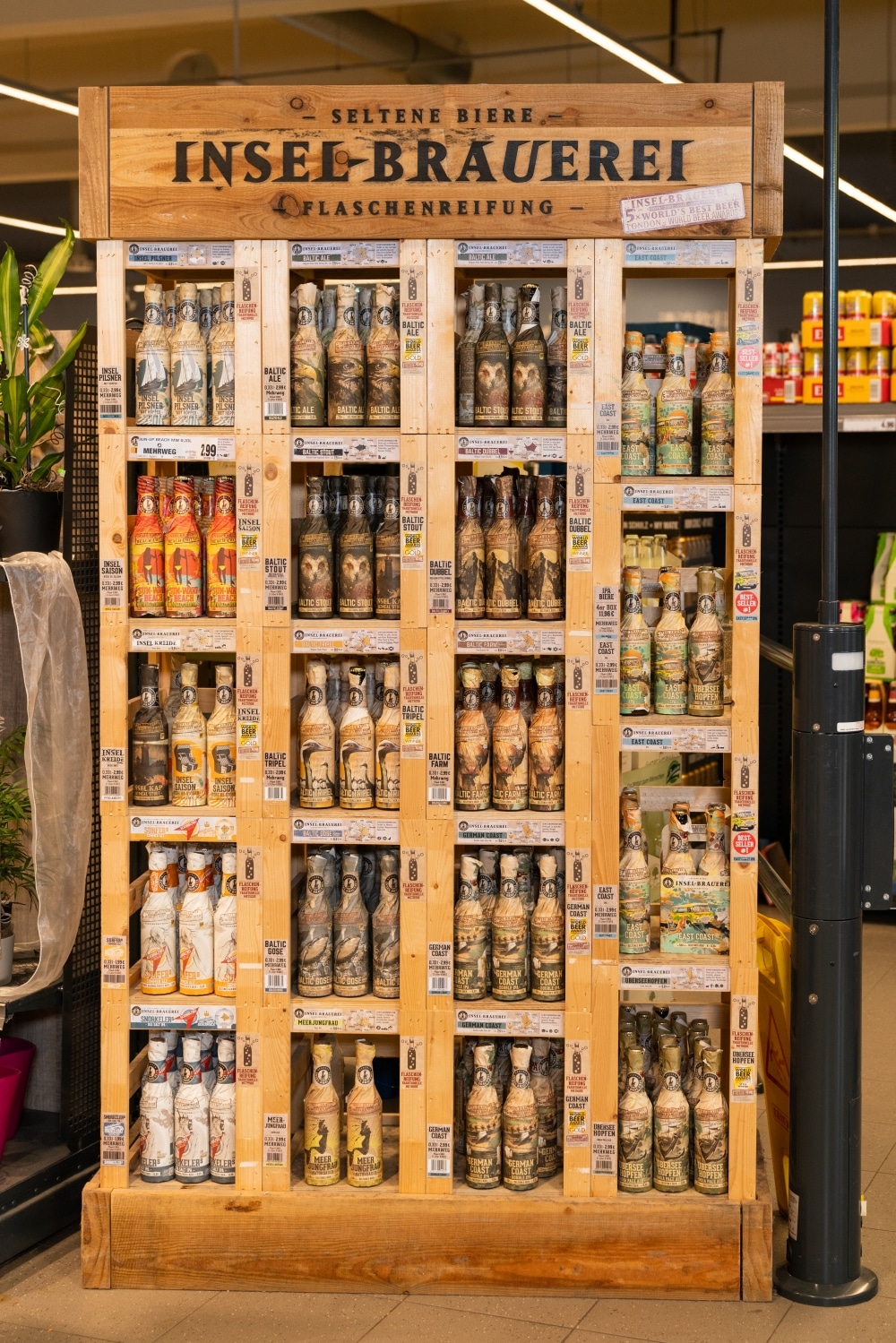 Ein Holzschrank mit verschiedenen Bieren der Inselbrauerei.