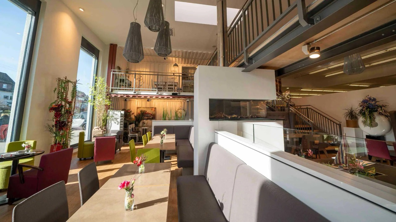 Lichtdurchfluteter Innenbereich eines an den Edeka-Markt anschließenden Cafés.