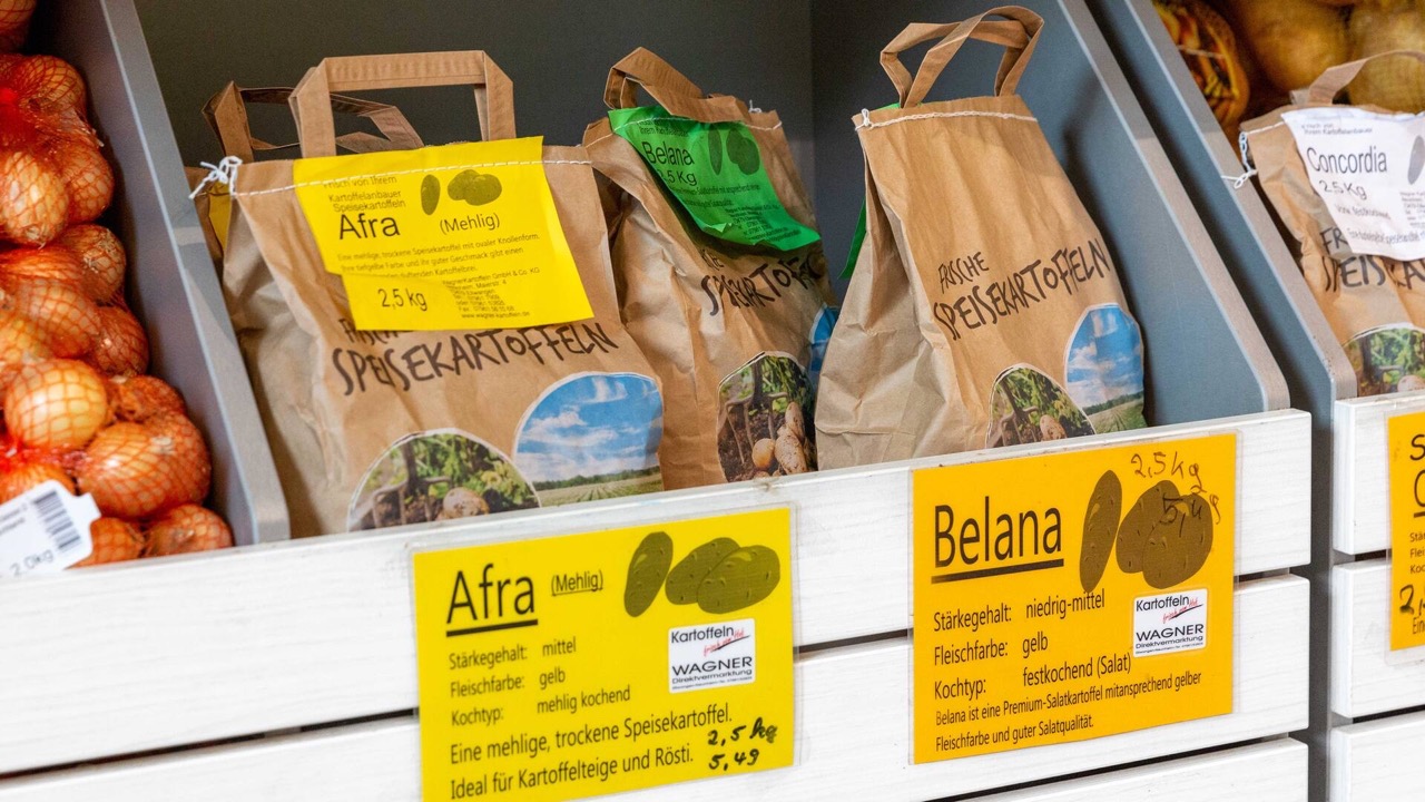 Drei Säcke Kartoffeln in einer Holzkiste.