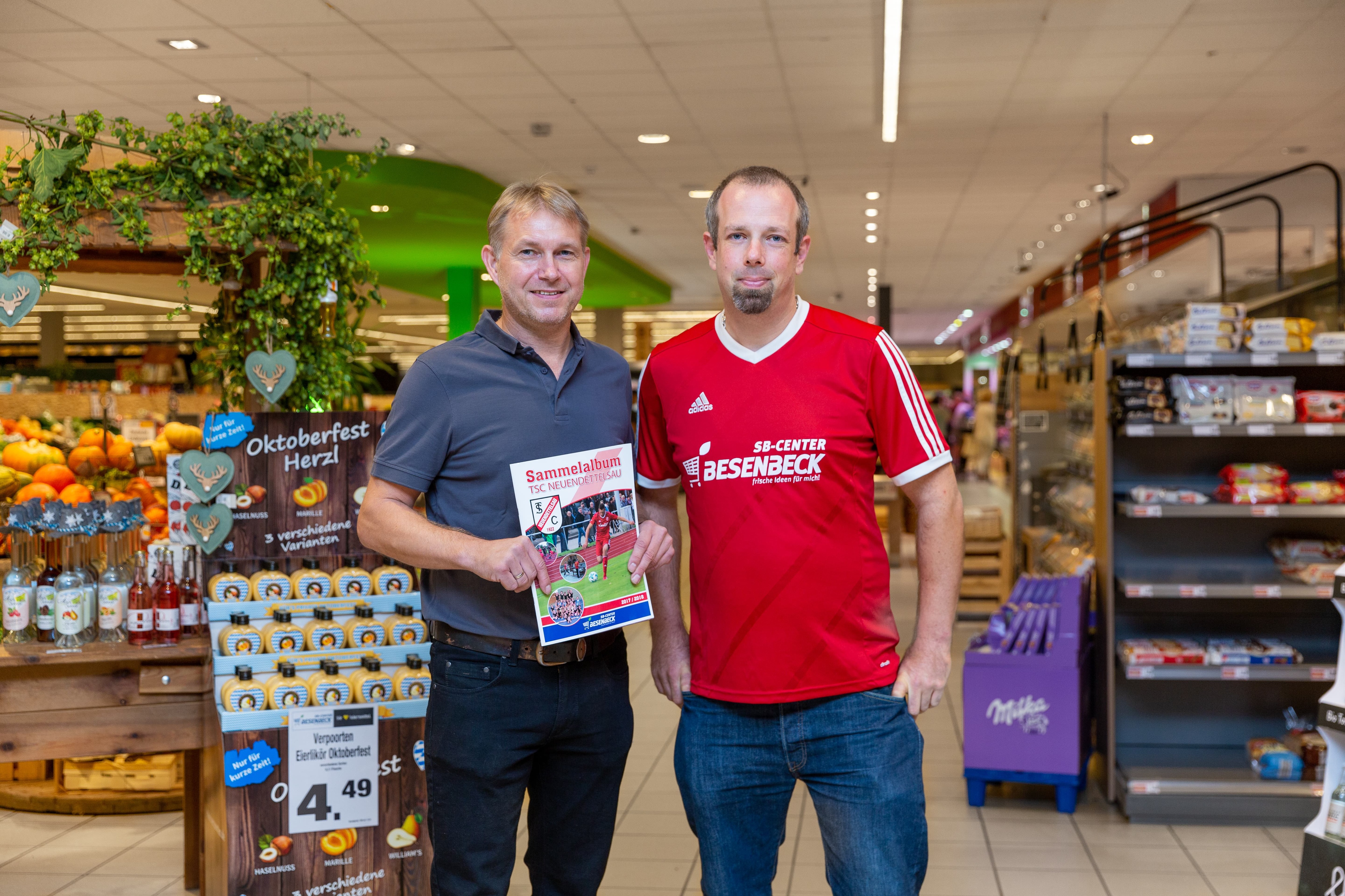 Der Inhaber eines Edeka-Centers mit einem Vertreter des lokalen Fußballvereins, der von Edeka-Center gesponsert wird.