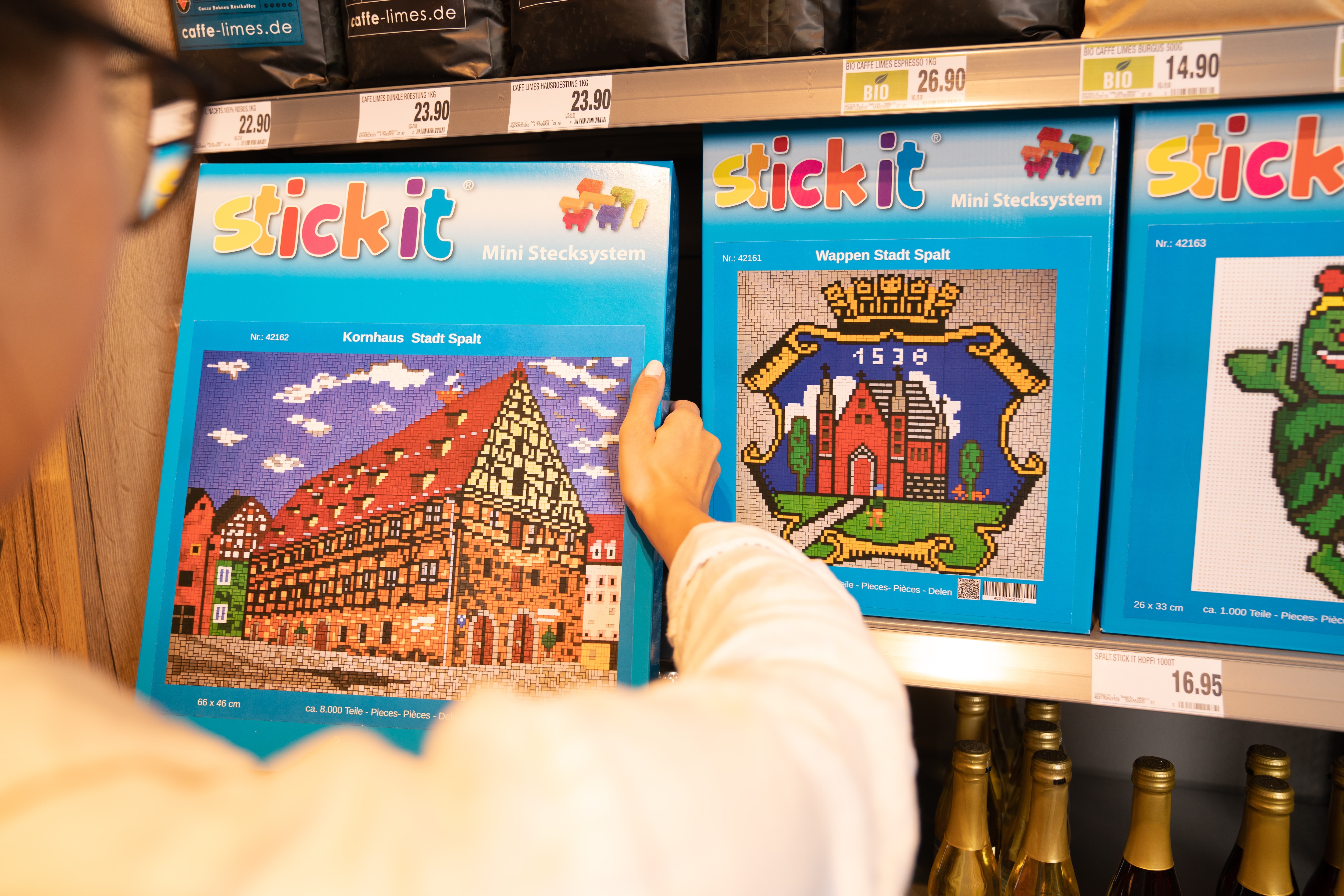 Eine Person hält eine Packung stick it Mini Stecksystem in den Händen. Das Motiv ist ein Fachwerkhaus.