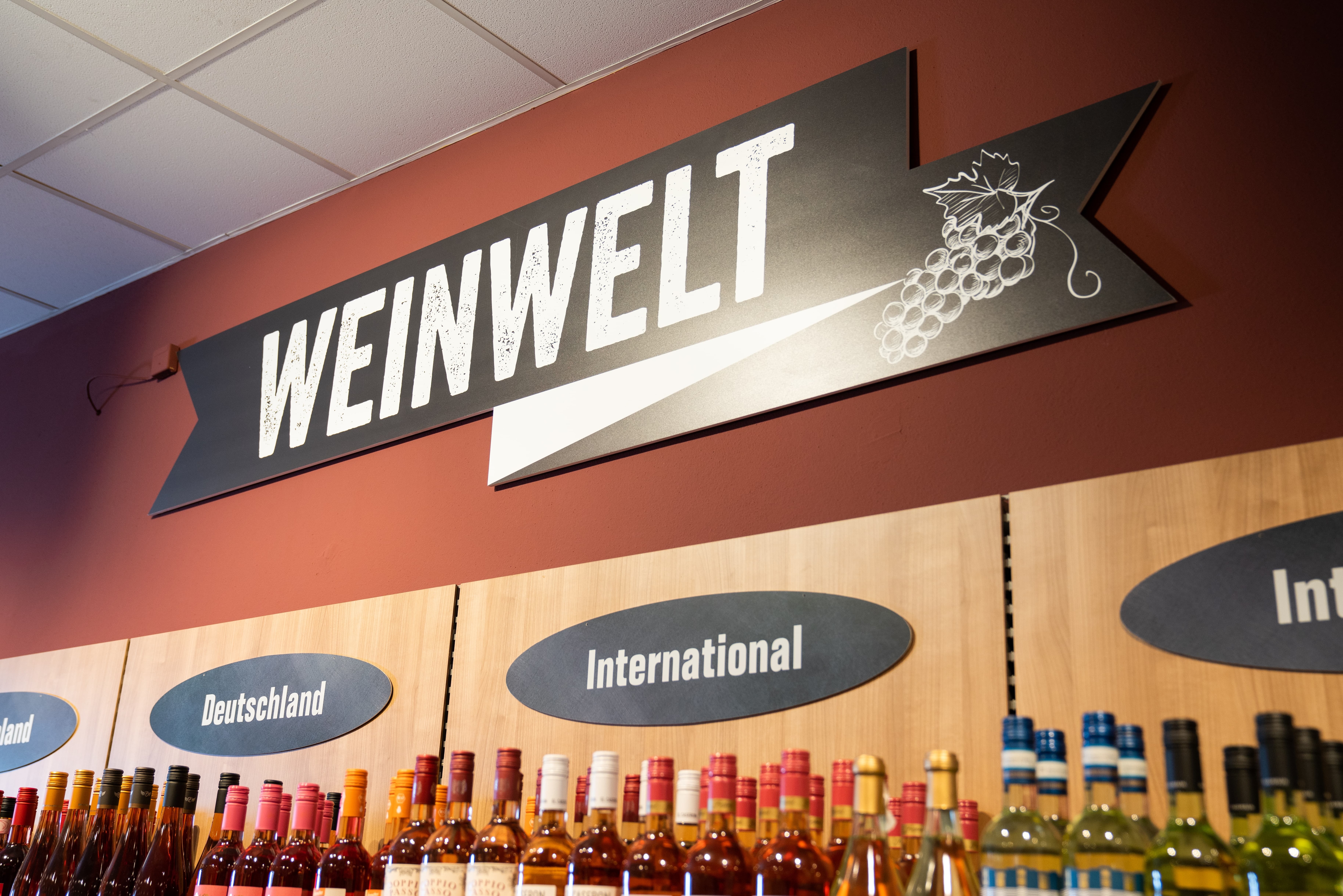Über dem Weinregal steht in großen Lettern: Weinwelt.