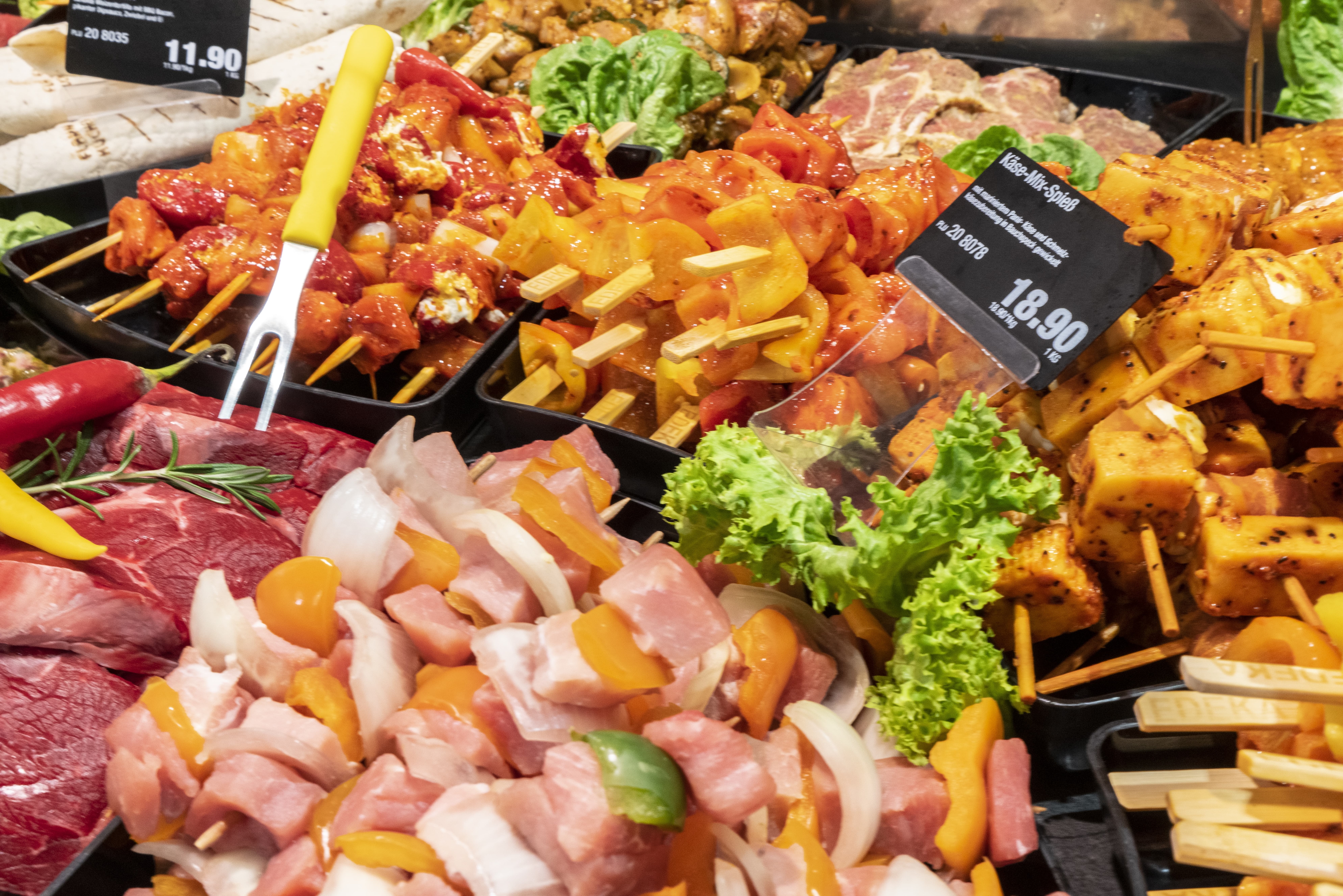 Close-Up einer Fleischauslage mit Preisschildern.