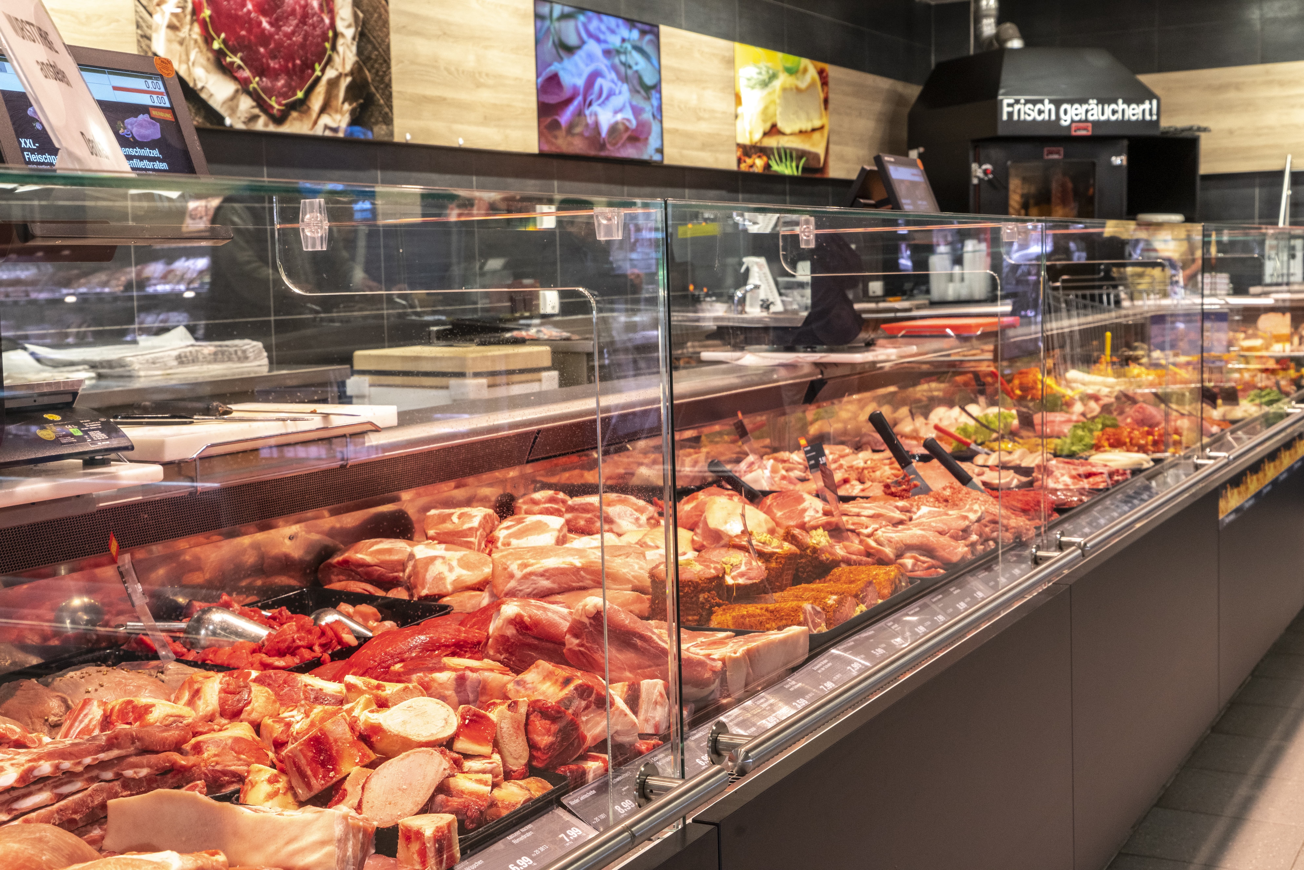 Die Fleischtheke eines EDEKA-Markts, im Hintergrund die Aufschrift: „Frisch geräuchert!“