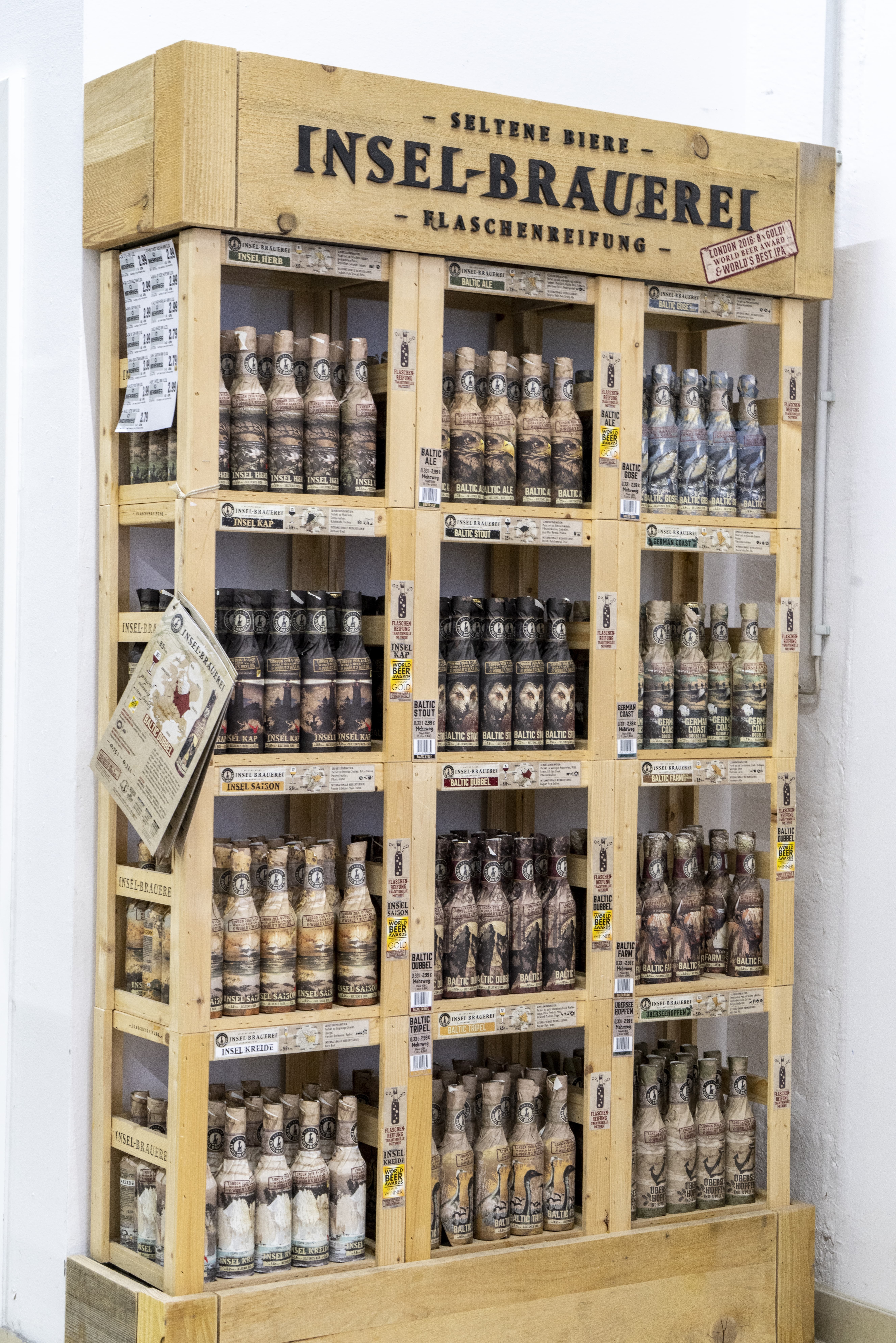 Ein Holzregal mit verschiedenen Biersorten der Inselbrauerei.