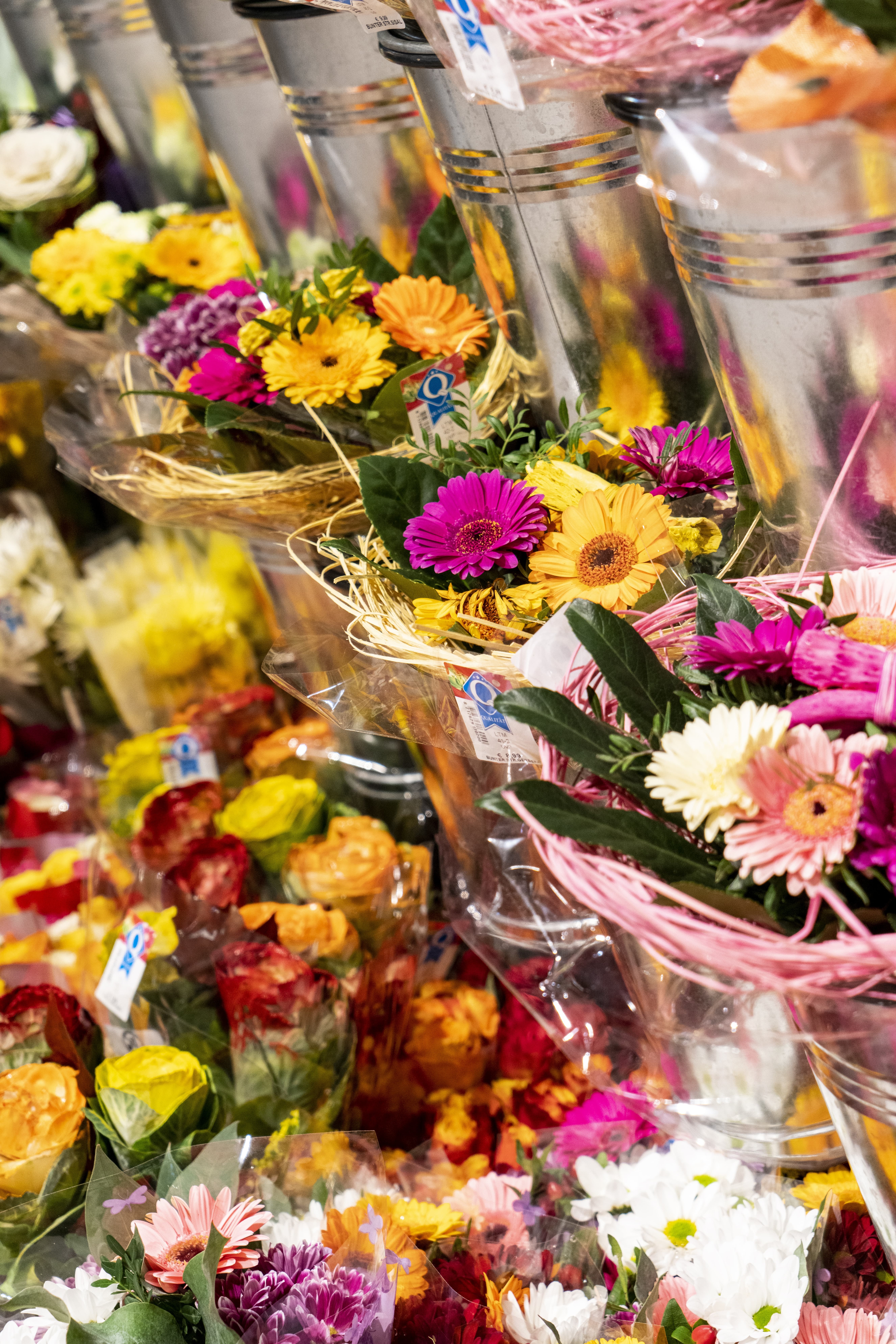 Verschiedene Blumensträuße in Töpfen aus Metal.