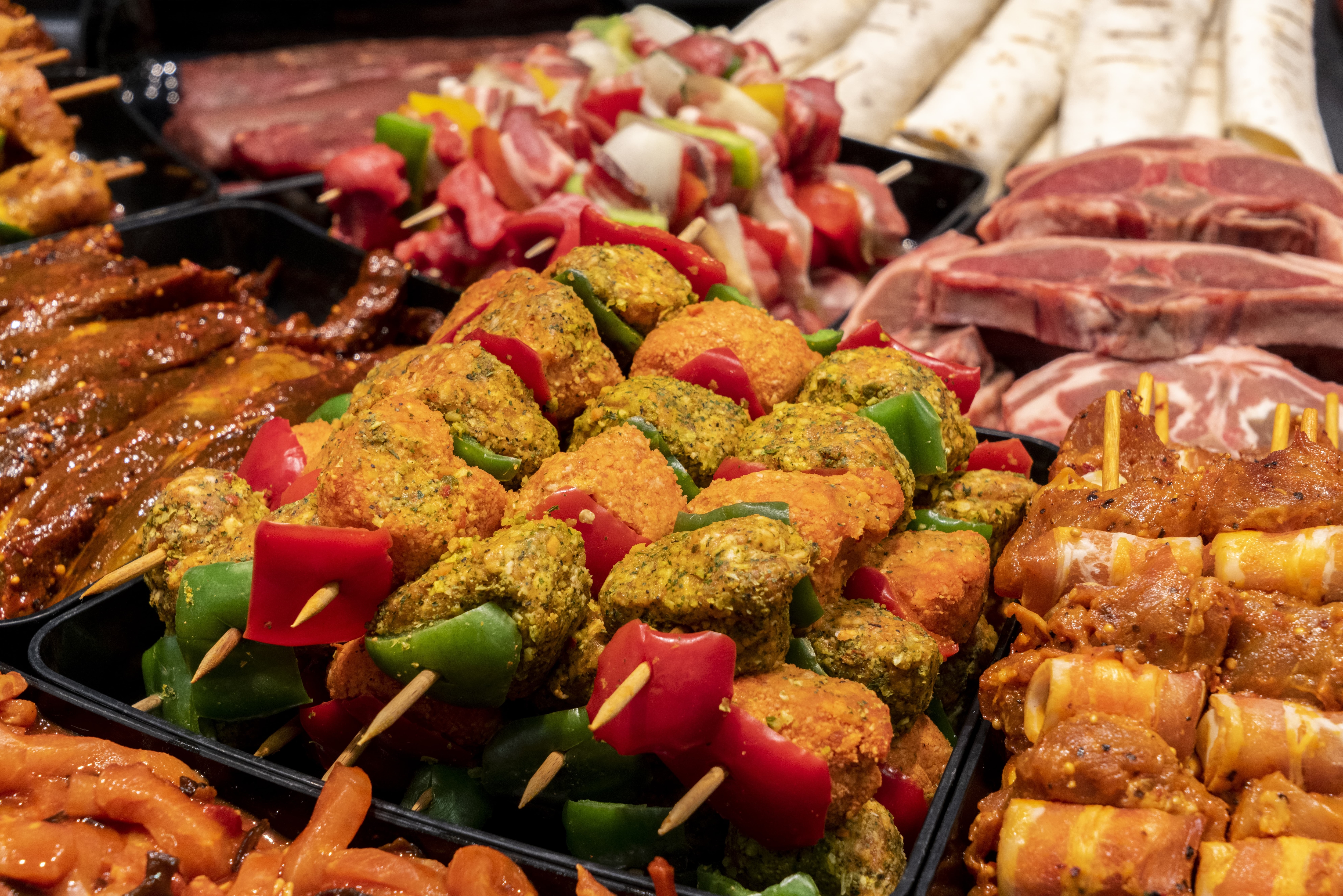 Nahaufnahme verschiedener Fleischspieße in einer Frischetheke eines Edeka-Marktes.