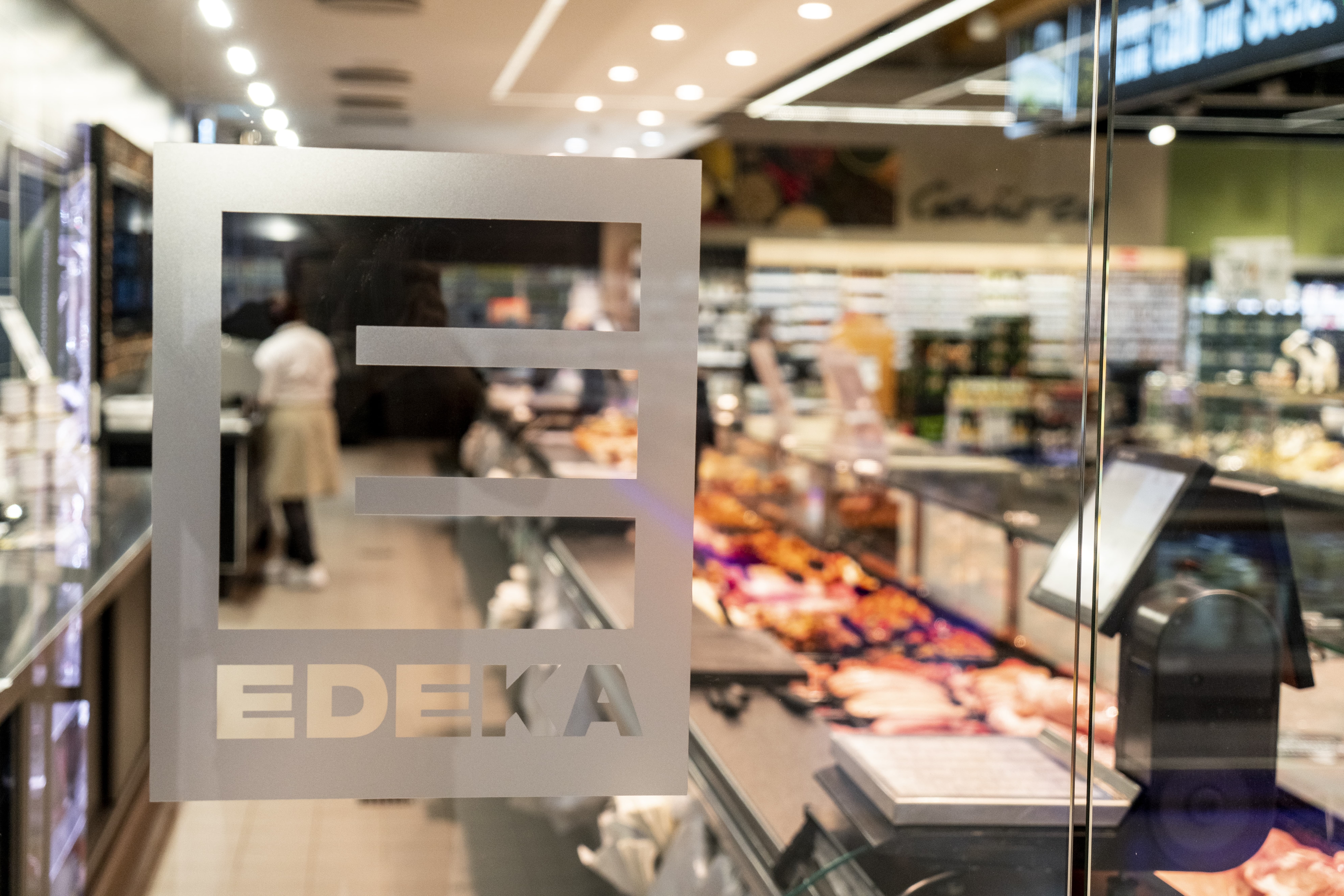 Eine Glastür bedruckt mit einem Edeka-Logo.