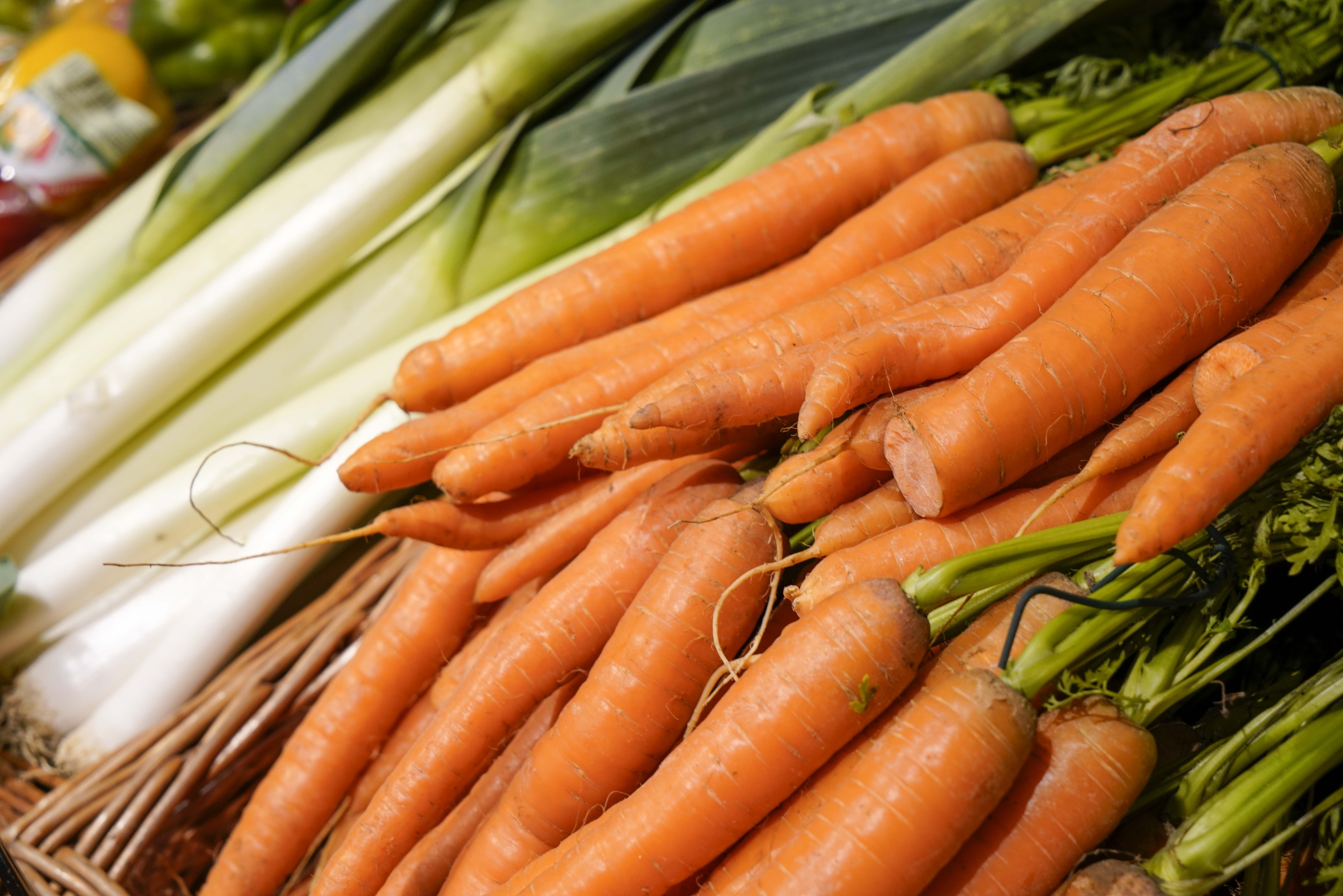 Nahaufnahme von Karotten in einem geflochtenen Korb.