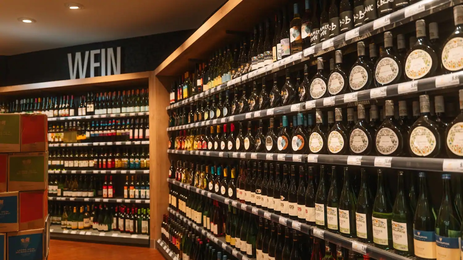 Weinregal mit Bocksbeuteln und anderen Flaschen.