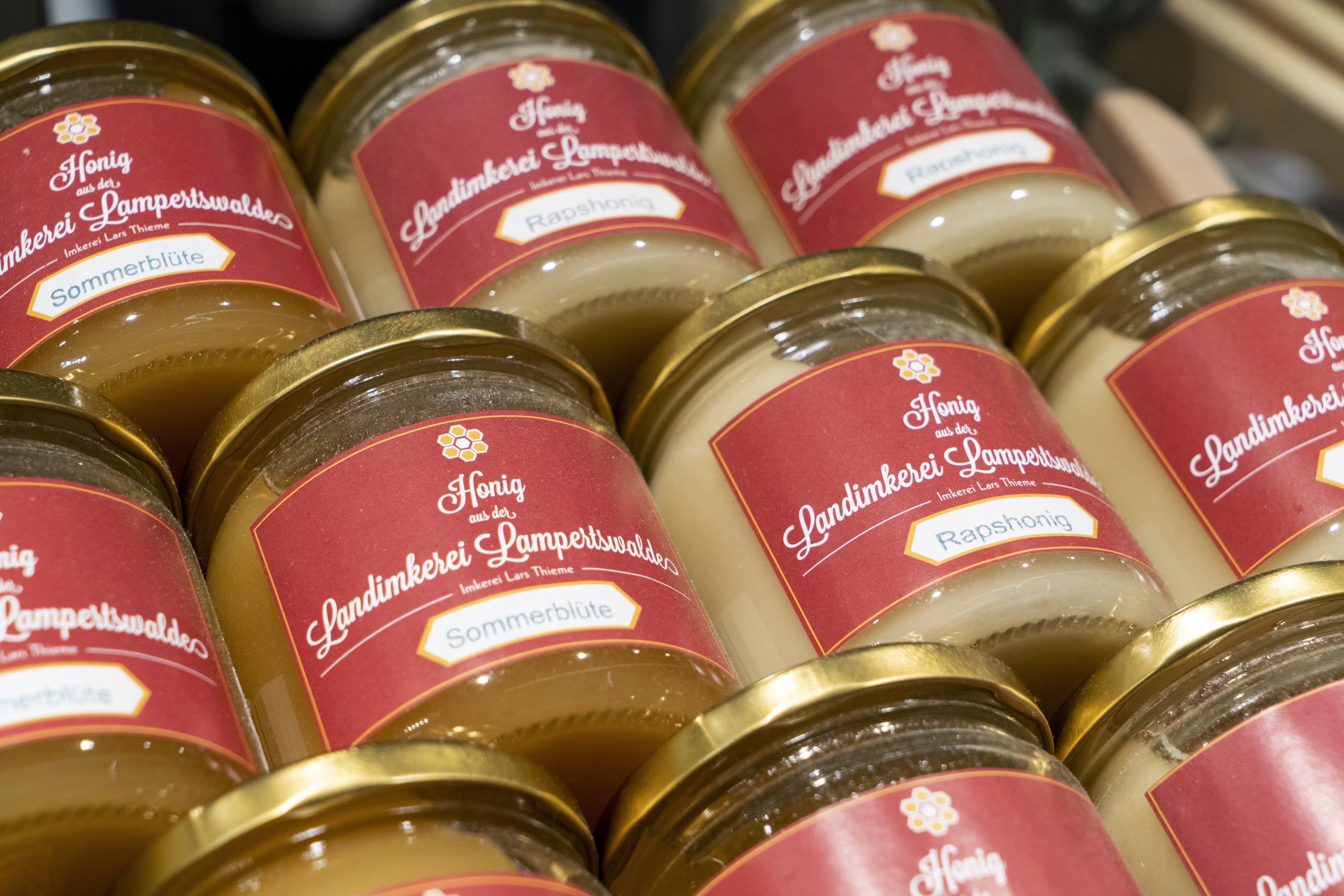 Liegende Honiggläser einer regionalen Landimkerei im Close-Up.