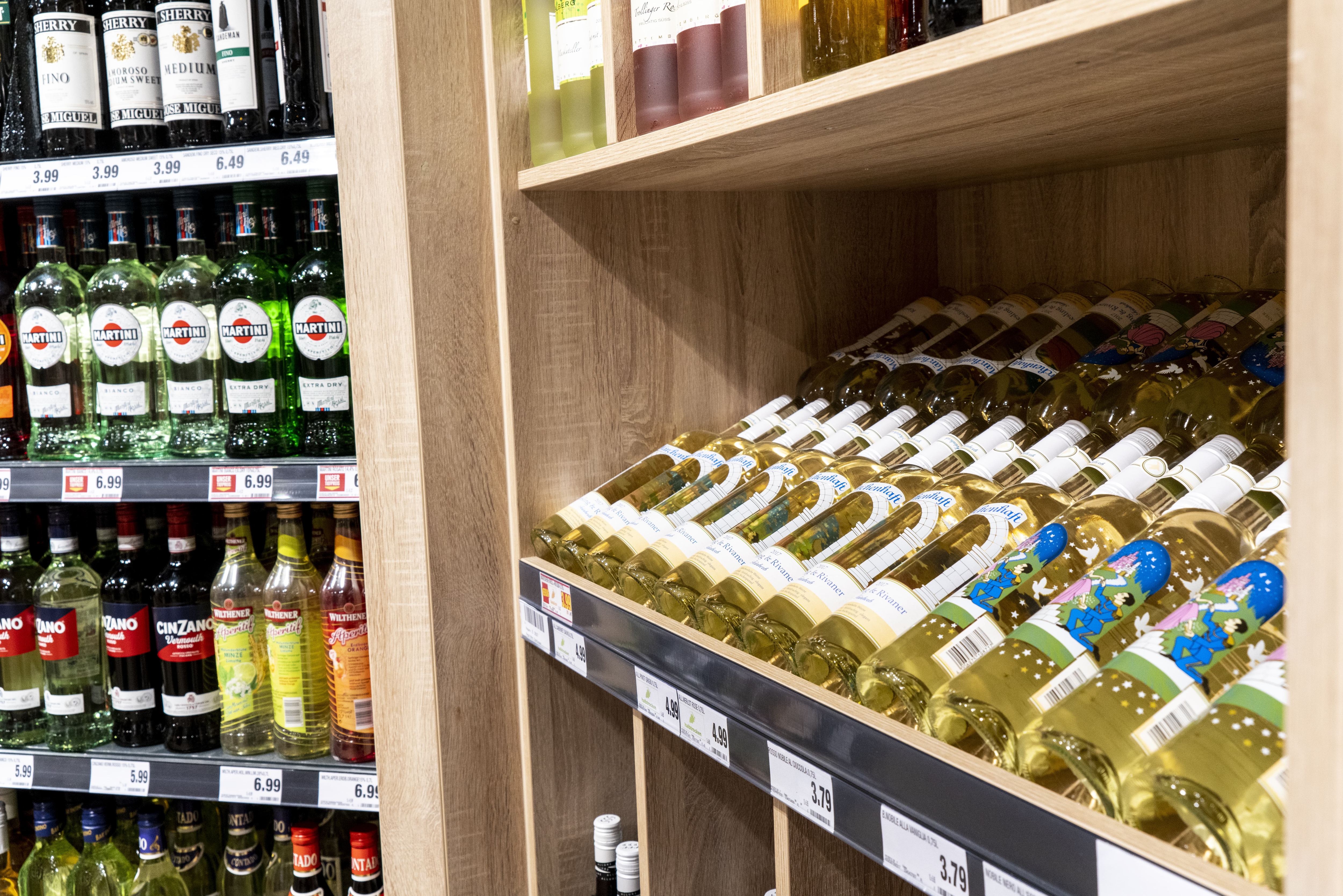 Nahaufnahme eines Regals mit Wein in einem EDEKA-Markt.